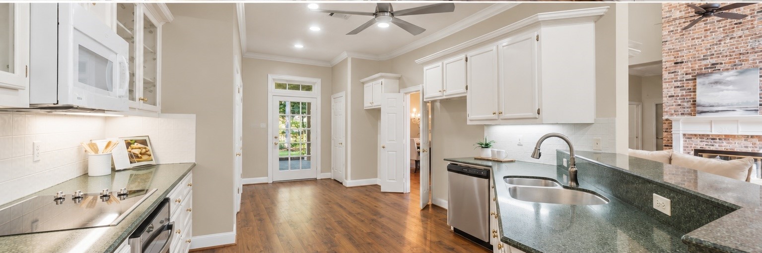 AI-generated visualization showing the kitchen with the existing wallpaper removed and replaced with neutral paint. Provided to illustrate the potential impact of a simple cosmetic update; actual property currently has wallpaper.