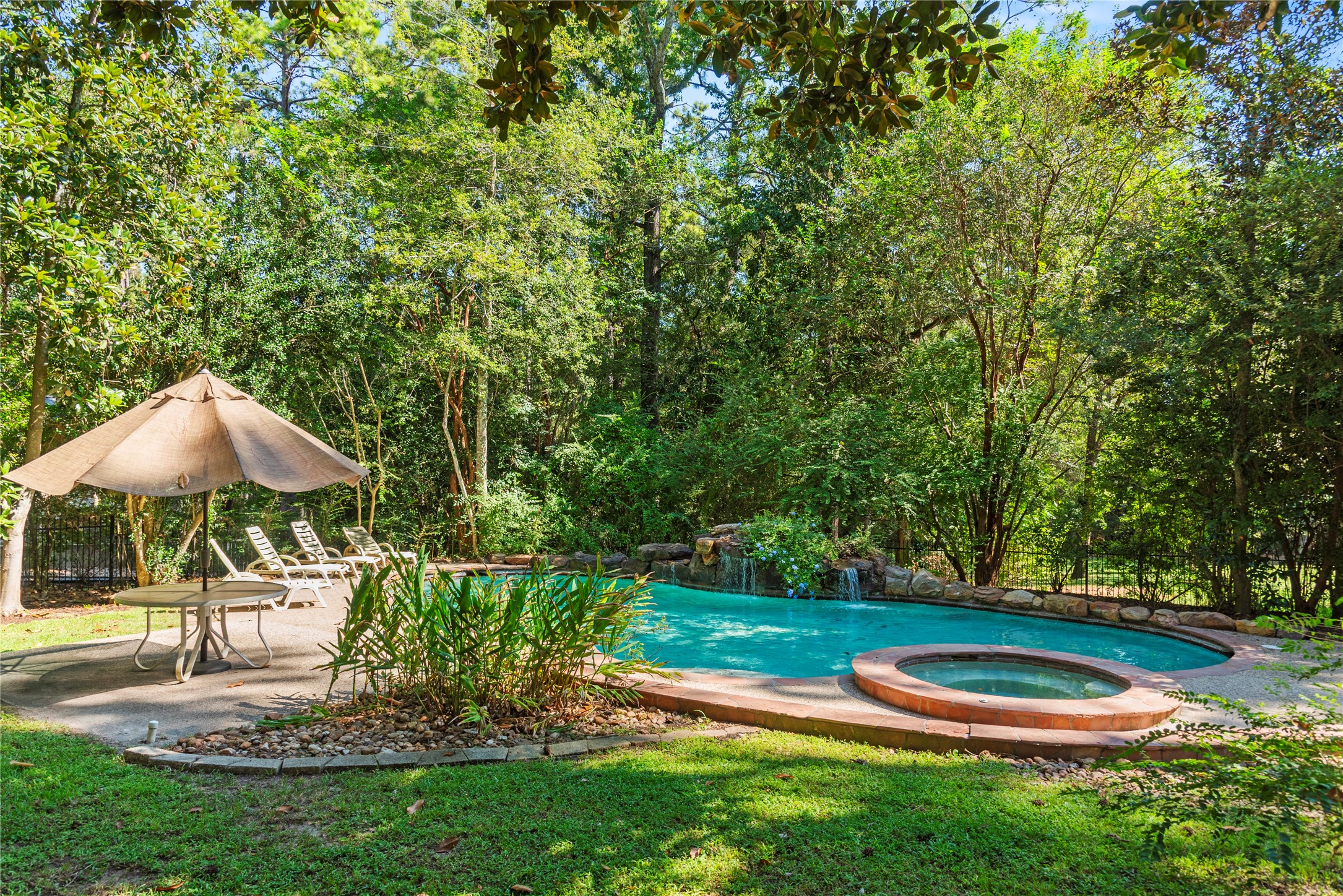 Resort-like pool and spa tucked beneath a canopy of mature trees, complete with rock waterfalls and generous space for lounging and entertaining.