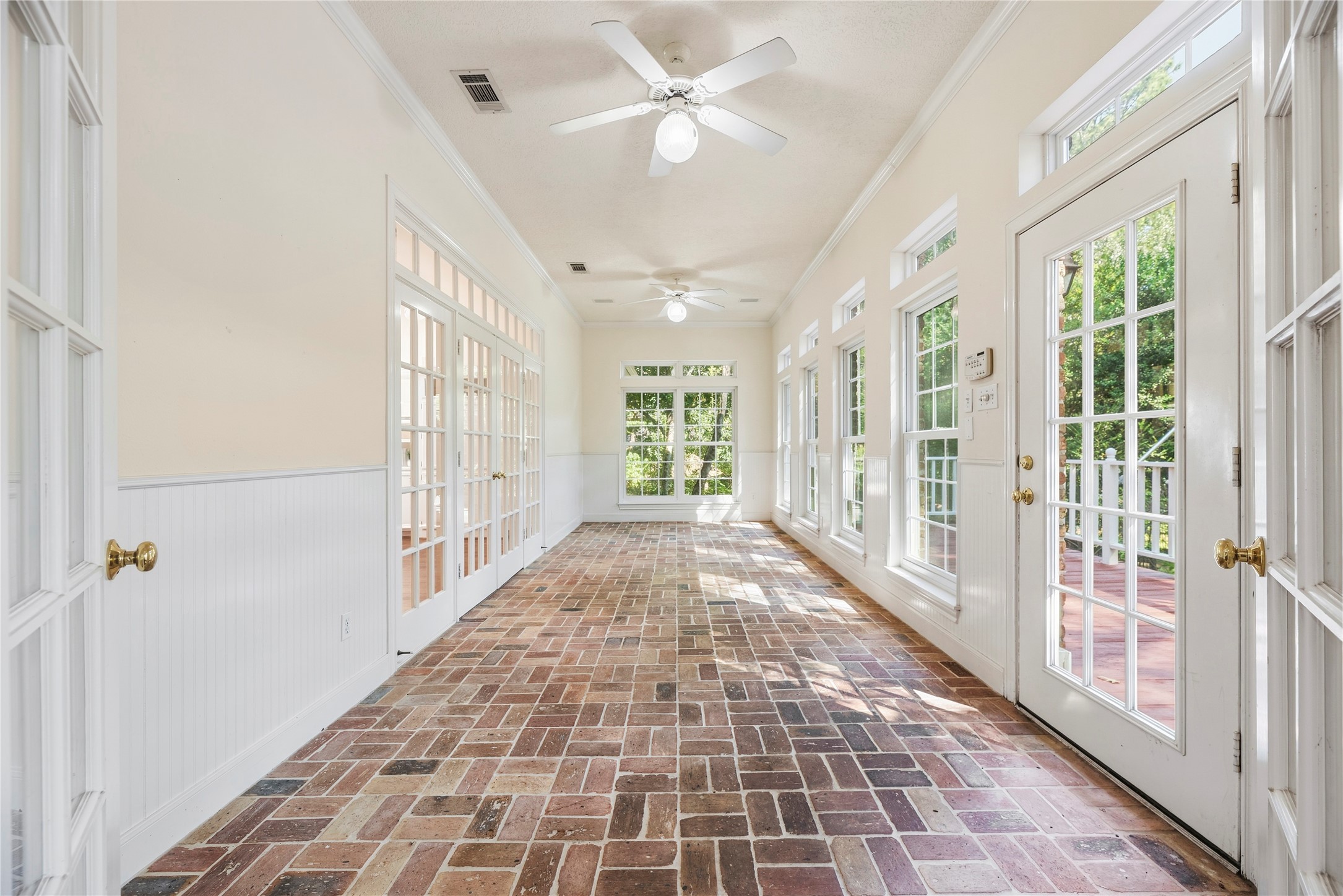 Beautiful sunroom with brick floors overlooking the pool, back porch, and back acre of land