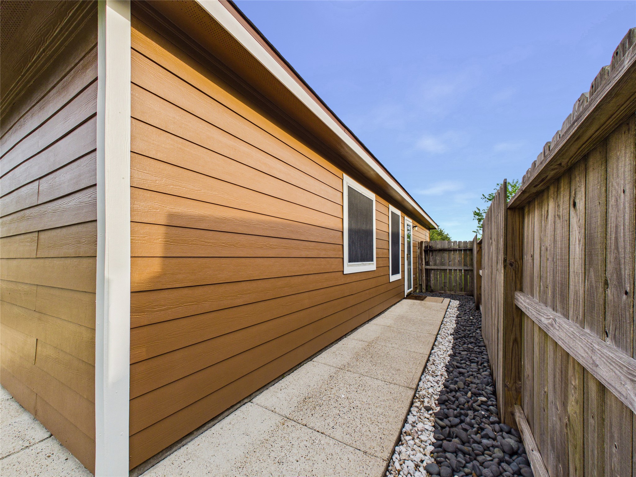 A charming walkway guides you from the home to a backyard.