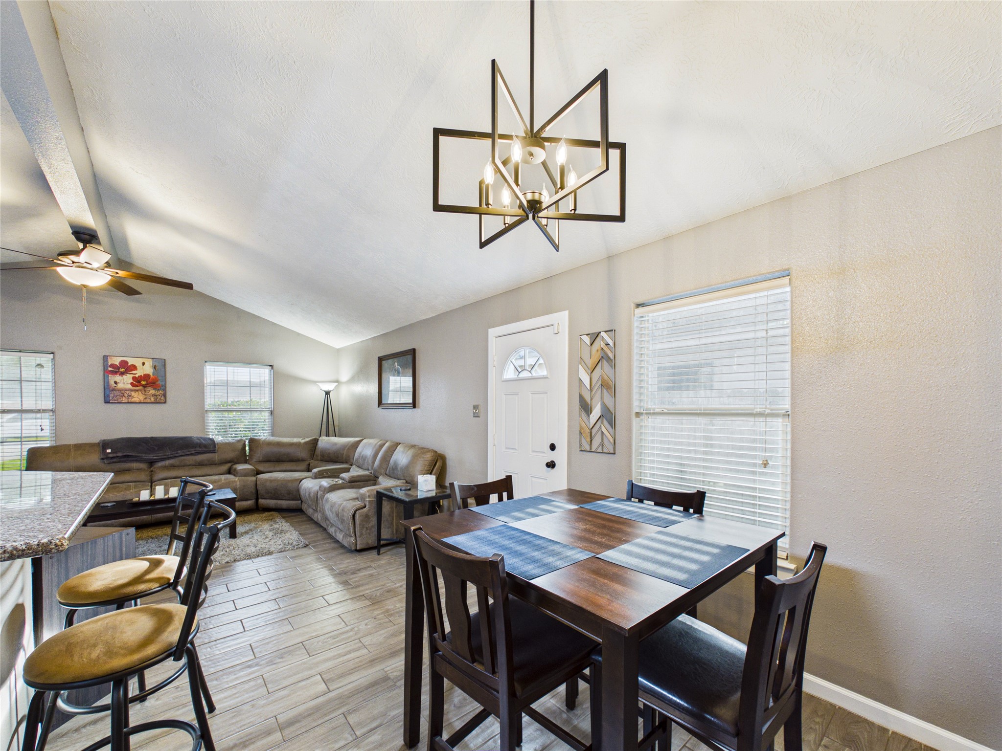 Bright and inviting open-concept living area combo showing off the stylish dining space and modern light fixtures. Bright and inviting open-concept living area combo showing off the stylish dining space and modern light fixtures.