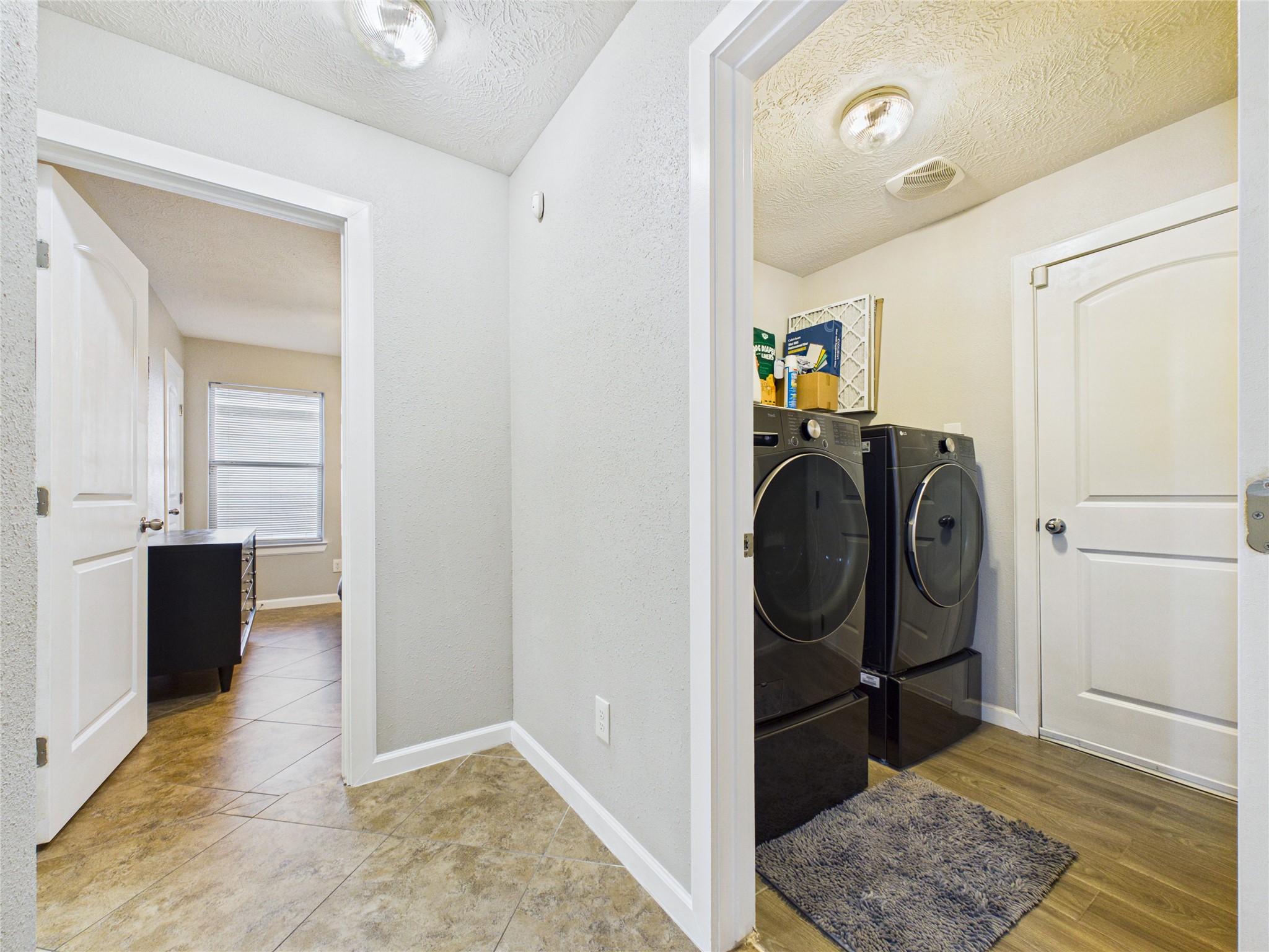 Laundry room and a welcoming hallway leading to bedrooms. Tile flooring and fresh paint continued throughout.