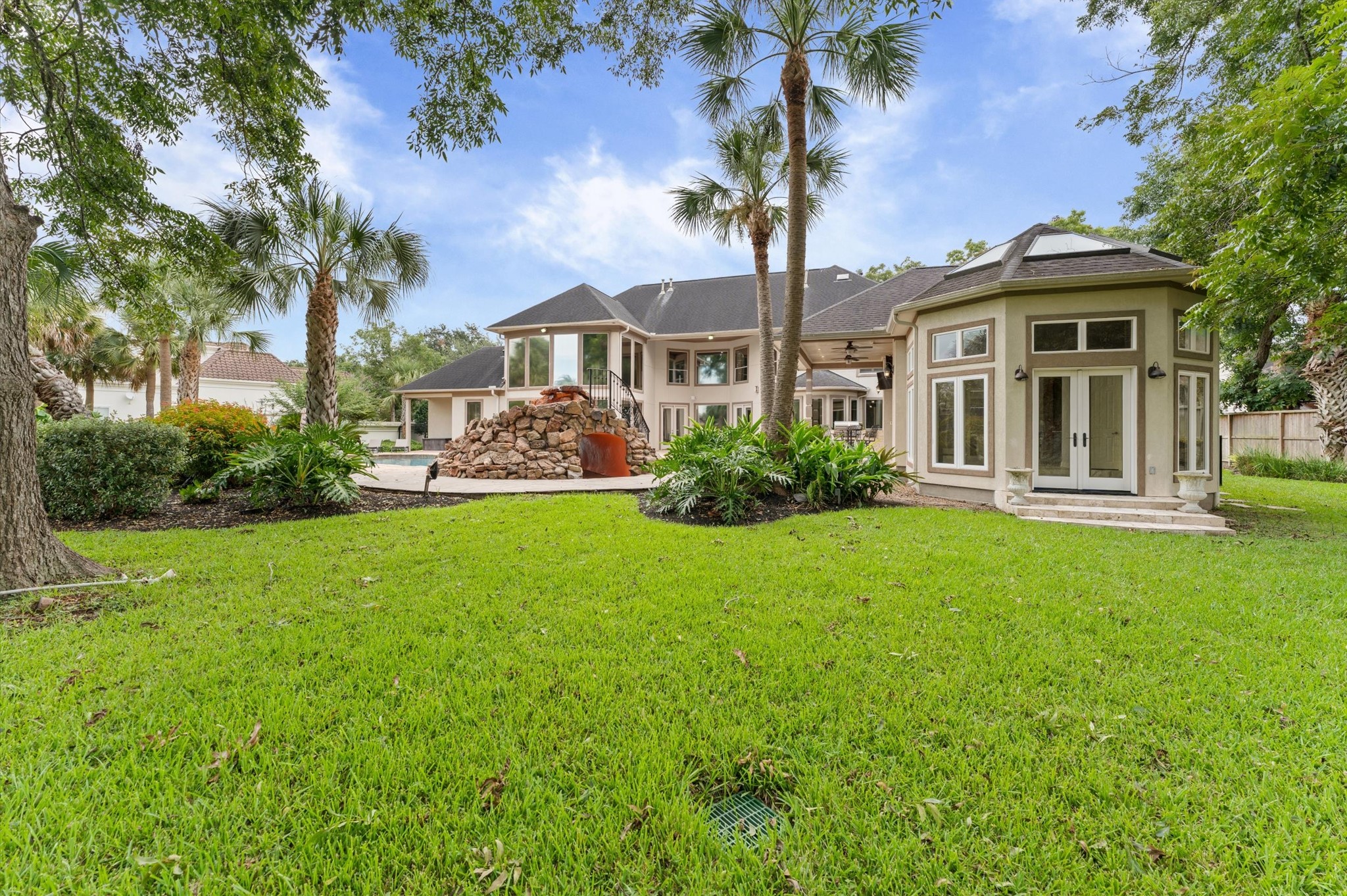 This view of your home shows beautiful St. Augustine grass, several palm trees and the door on the right leads you into the sunroom of the cabana.