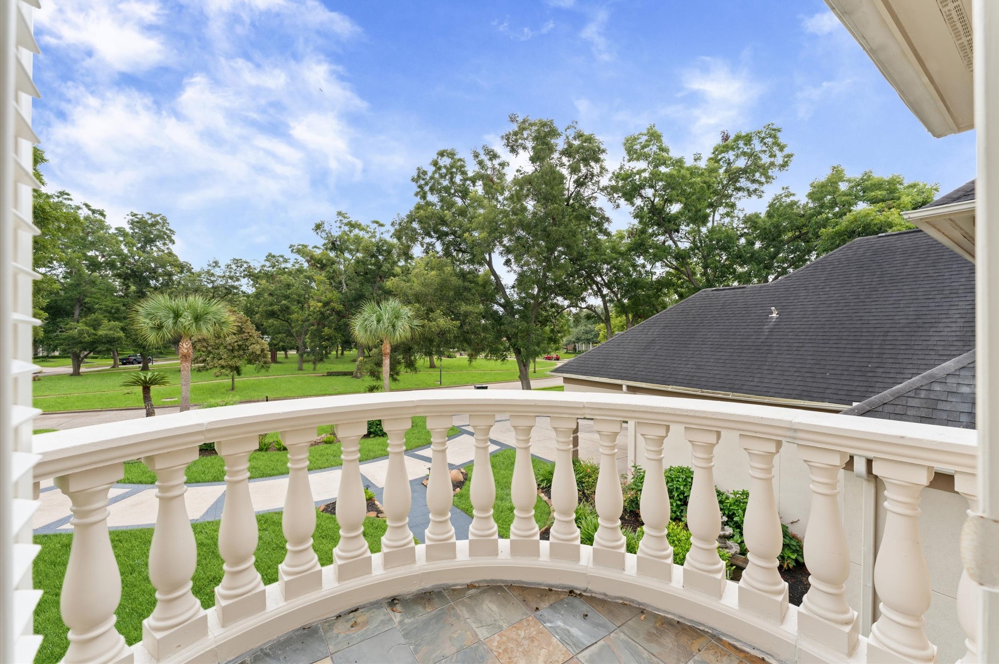 The upstairs balcony overlooks the tree-shaded park in front of the house.