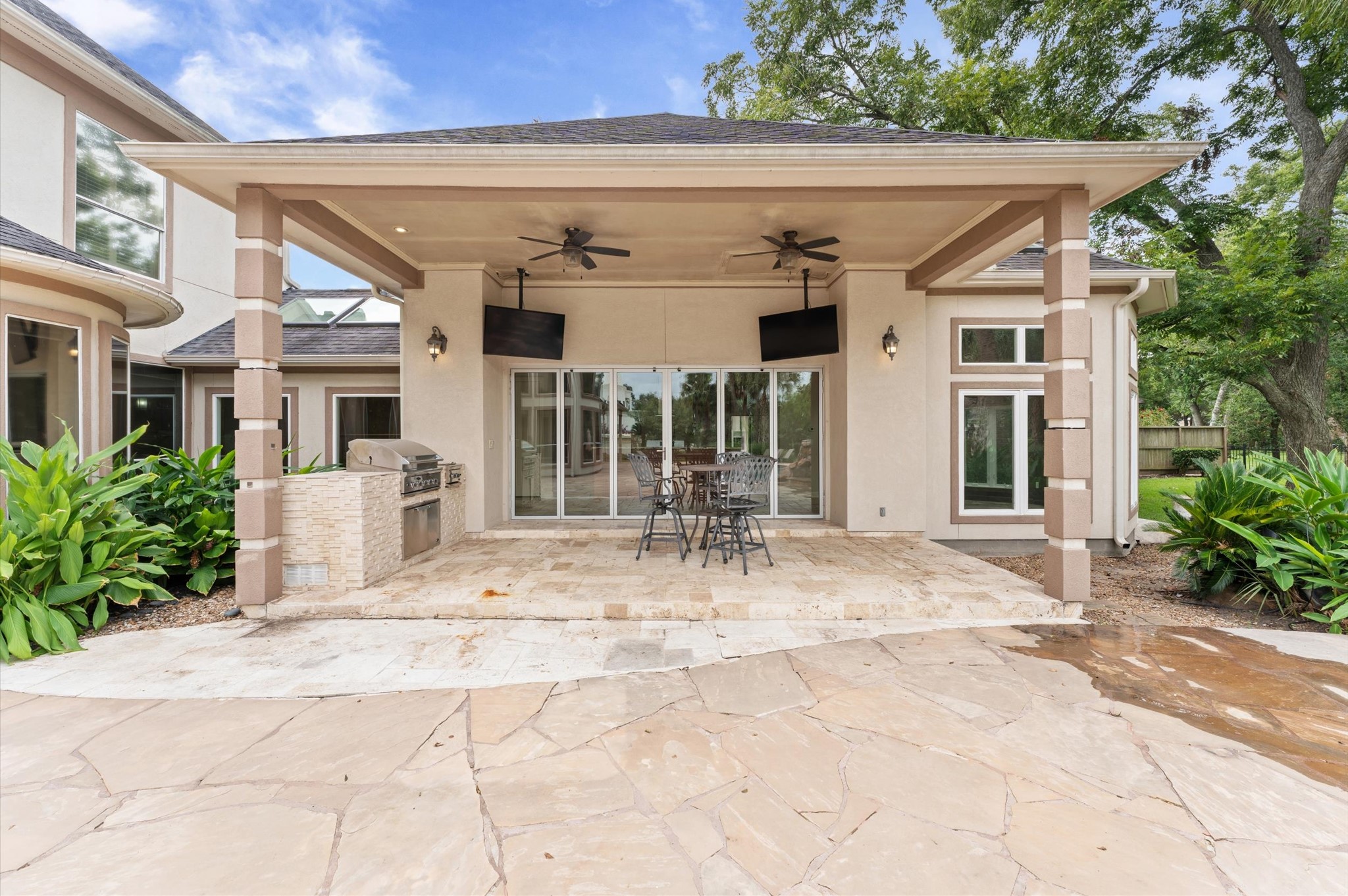 This is a view of the outdoor kitchen and into the cabana. Notice the double fans and TV's.