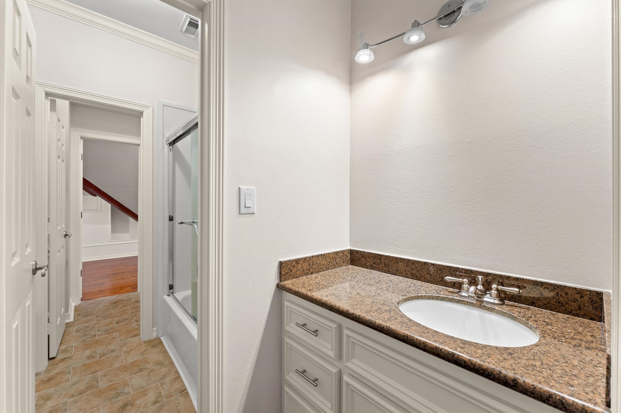 This bathroom has a separate door for the tub/shower and one for the toilet. It also leads into a huge climate-controlled storage area that has a spiral staircase to the garage and a hand sink.
