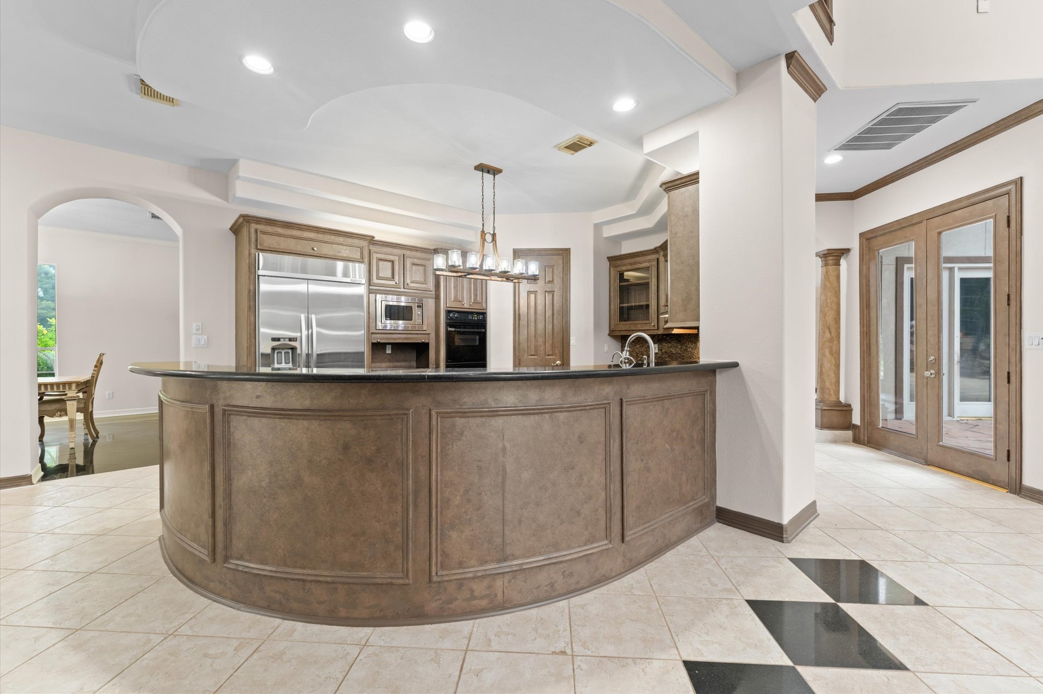 A view into the kitchen that is open to the breakfast area shows a large circular breakfast bar.