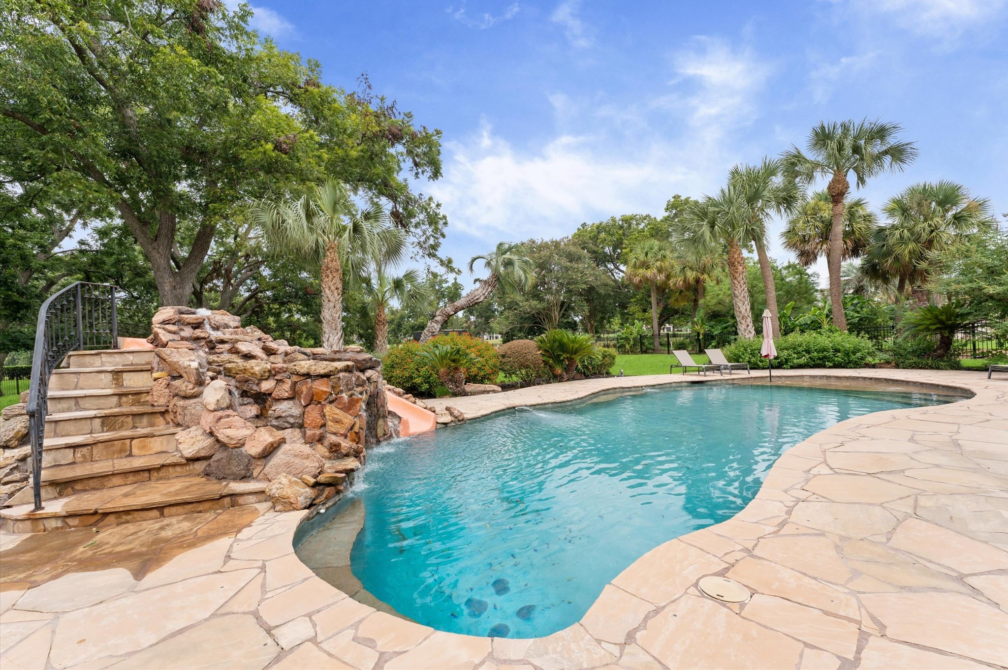 This pool is stunning, has a water slide with waterfall and under rocks is your very own grotto! The foliage around the pool and throughout the yard provides a tropical feeling as if you are always on vacation at home!