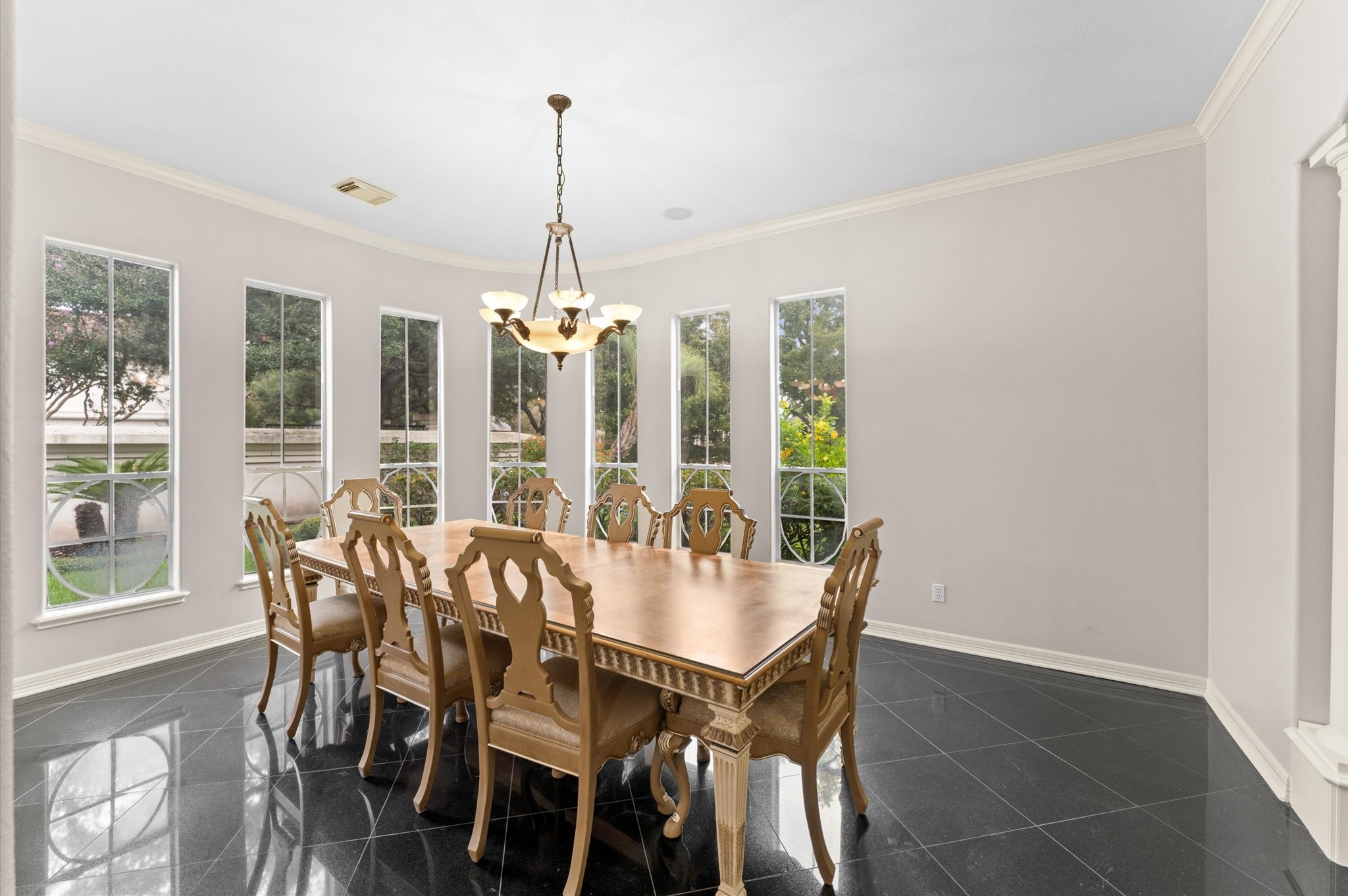 The dining room is highlighted by the custom windows, crown-molding and gorgeous chandelier adds ambience.