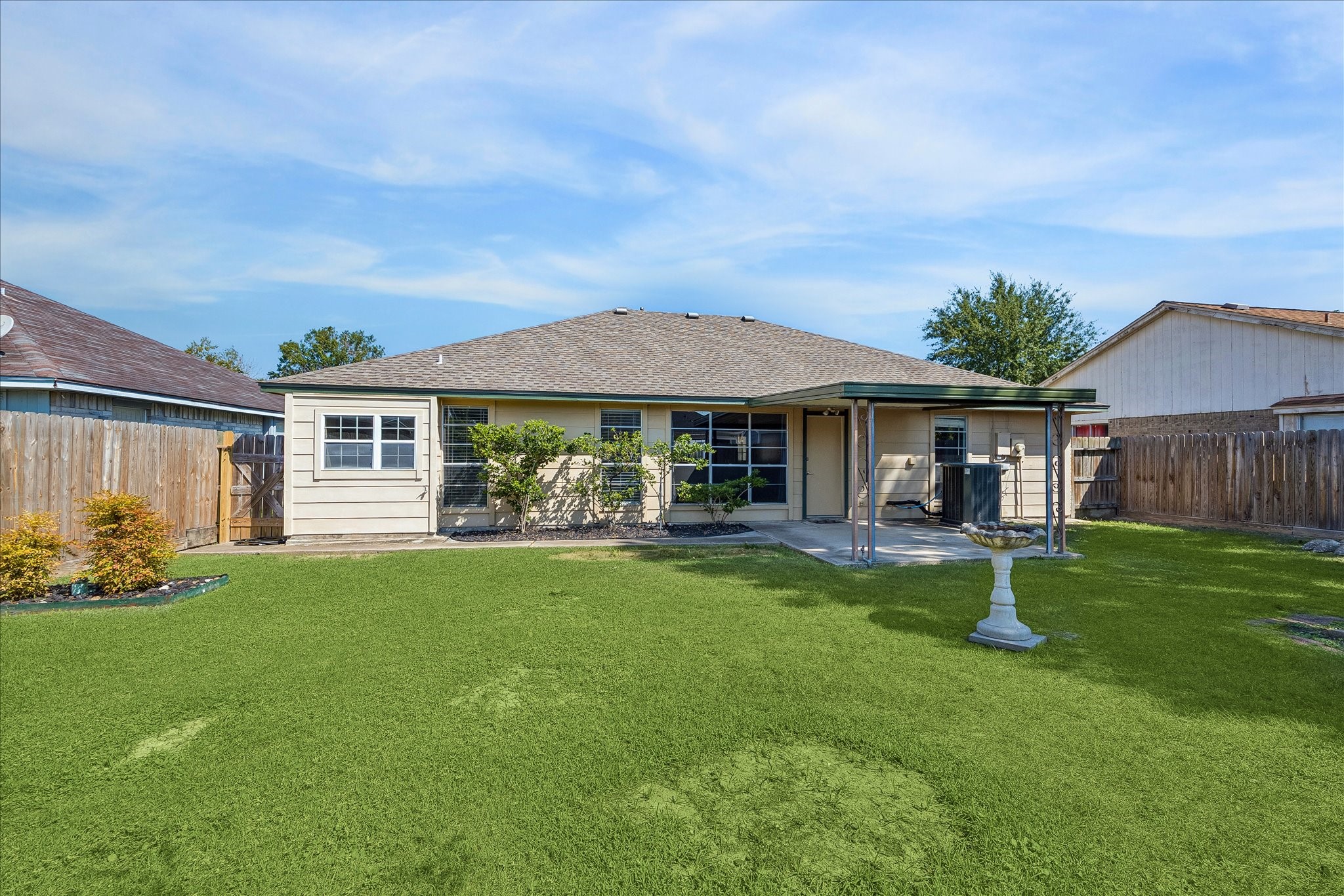 Spacious fenced backyard offers an open stretch of lawn with the covered patio positioned just off the rear of the home.