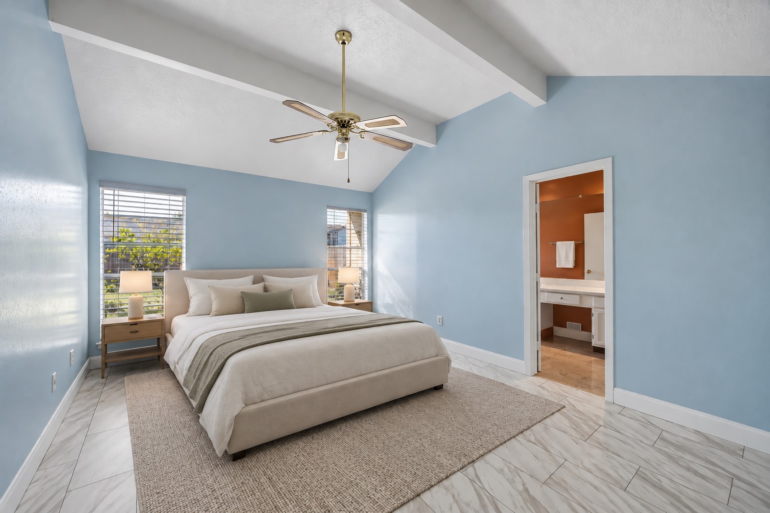 Shaw vinyl plank flooring, installed in 2020, runs through the primary bedroom beneath the dramatic vaulted ceiling. Windows on two walls bring in additional daylight.