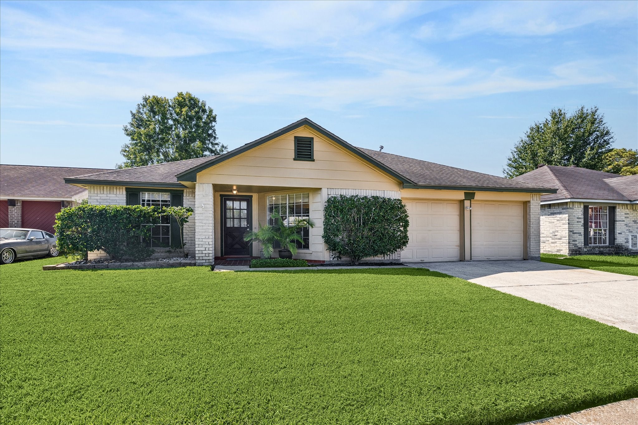 Alternate curb view highlights the homes classic single-story profile, brick-and-siding exterior, wide driveway, and neatly maintained landscaping.