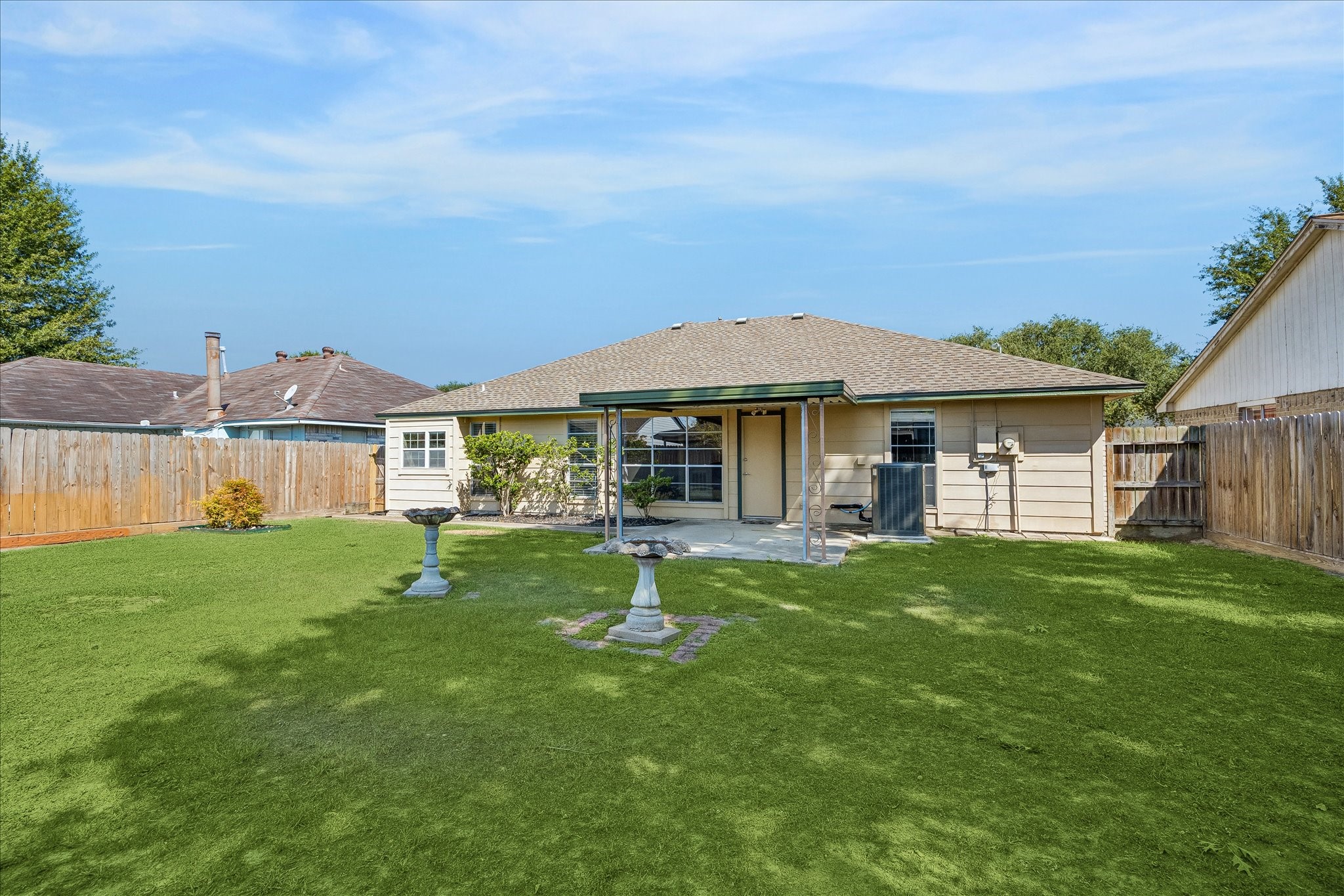 Another backyard angle shows the depth of the 6,300 SF lot and the separation between the home, covered patio, and open lawn.