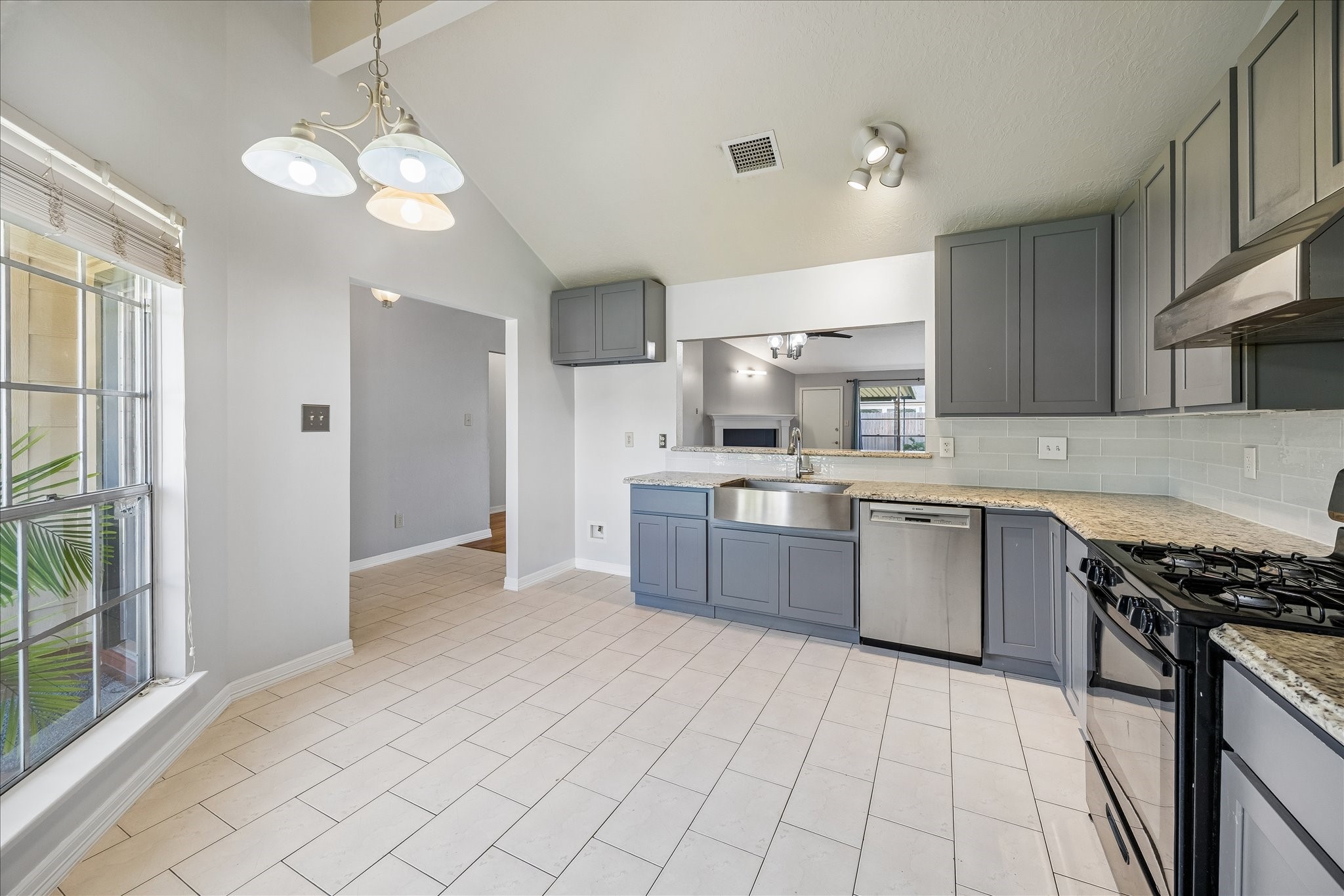 Kitchen opens directly toward the dining and living areas, creating an easy connection between the main gathering spaces. A large window keeps the room bright throughout the day.