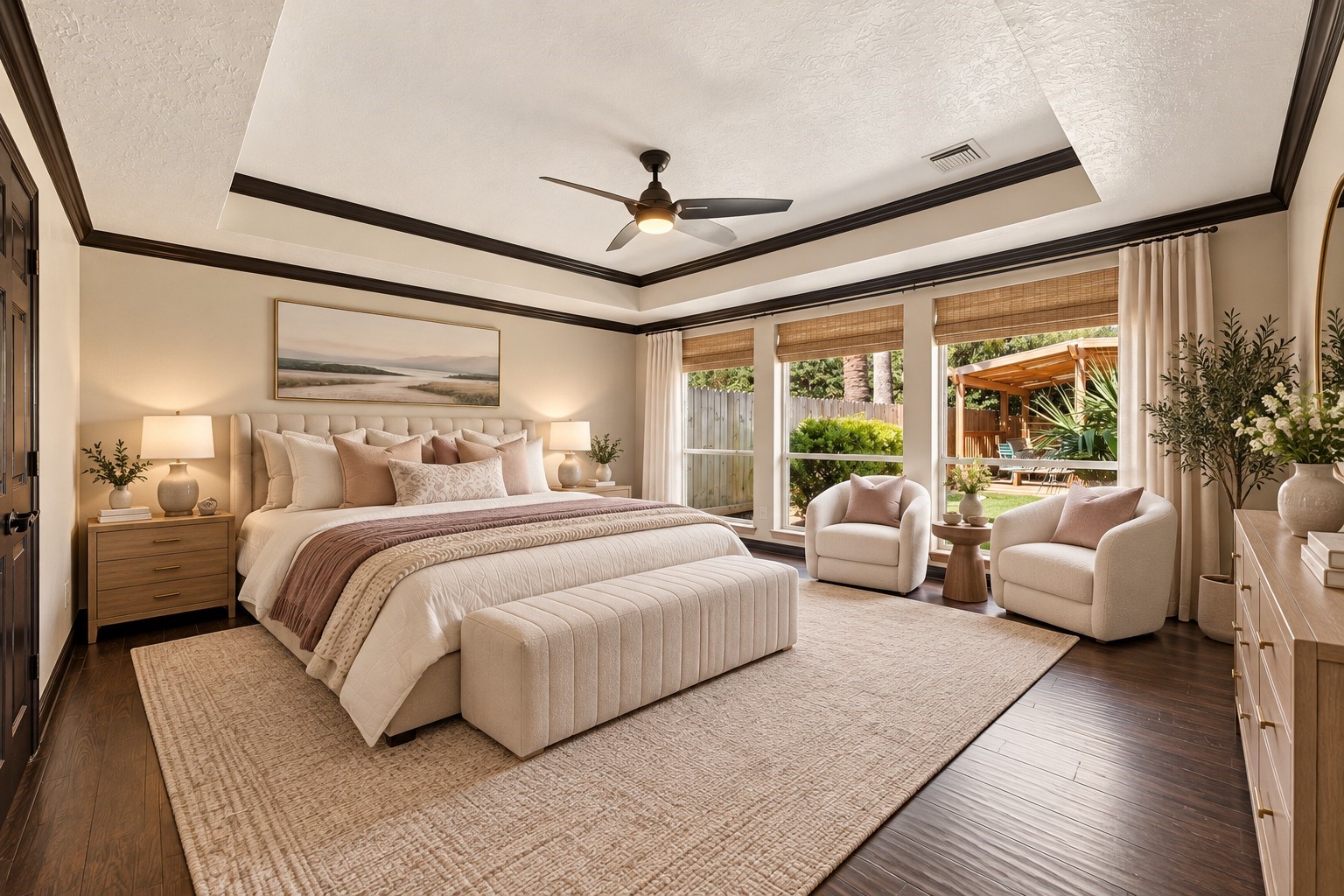 Experience luxury in the primary bedroom with elegant tray ceilings, located on the first floor, offering serene backyard views.