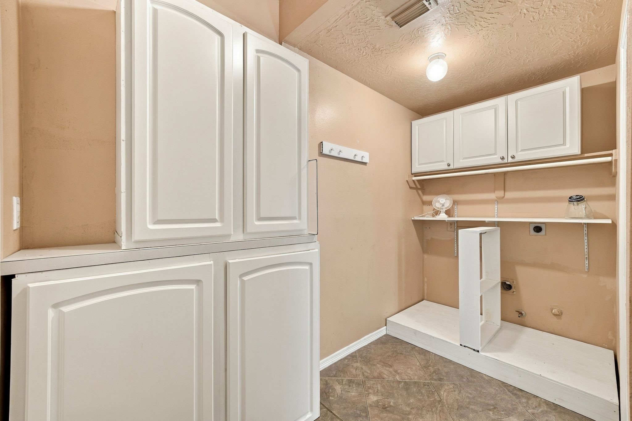 Conveniently located on the first floor, this spacious laundry room features ample storage and modern finishes for effortless organization.