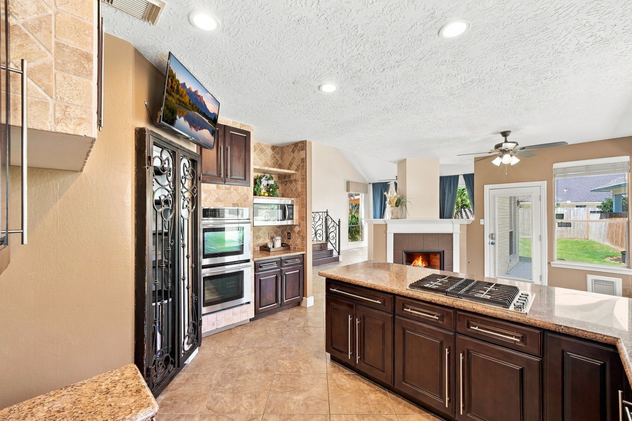 Create culinary masterpieces in this kitchen equipped with a double oven and expansive gas cooktop, all while enjoying the warmth of a cozy fireplace and abundant natural light.