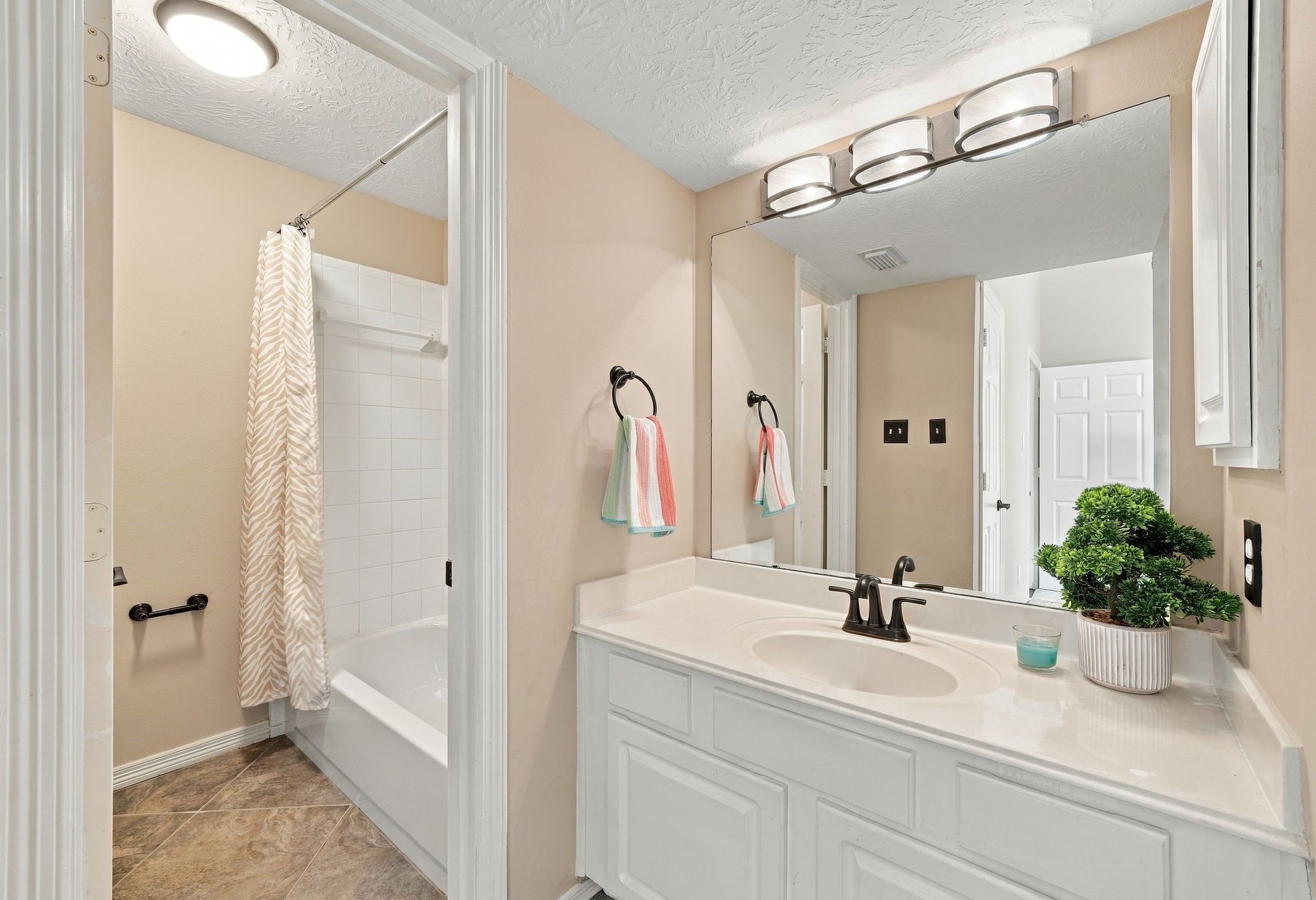 Step into this stylish en-suite featuring a versatile shower/tub combo, perfect for relaxation and convenience.