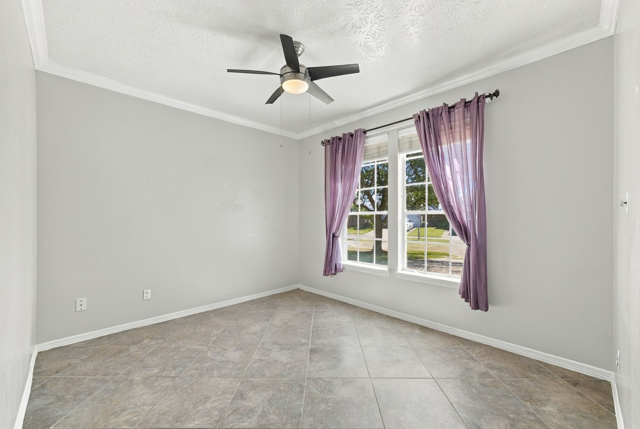 Bright and inviting, the first-floor room offers an ideal space for a home office or study, featuring ample natural light and sleek tiled flooring.