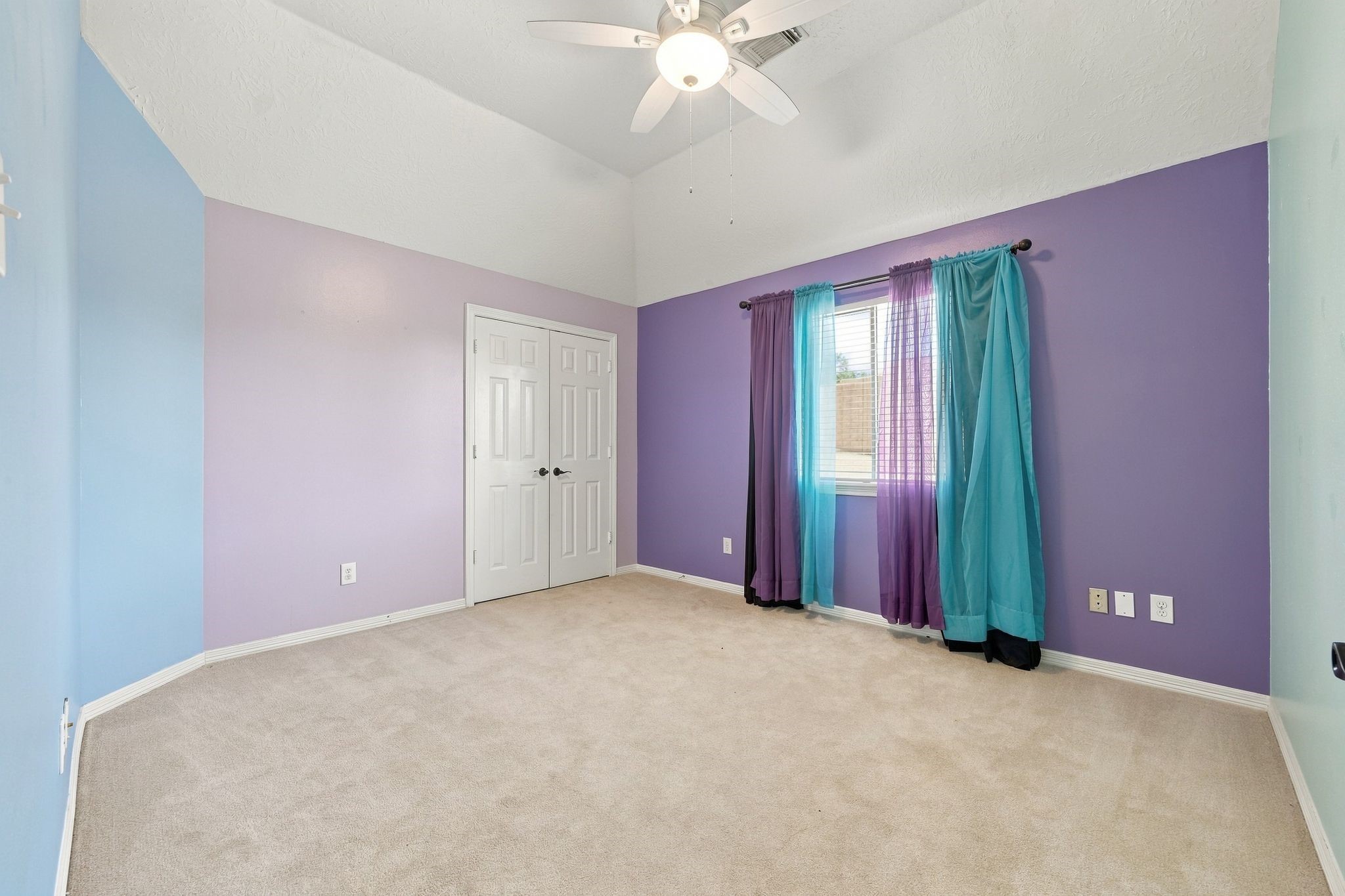 Bright and airy bedroom with vibrant, playful walls and a cozy atmosphere, ready for your personal touch.
