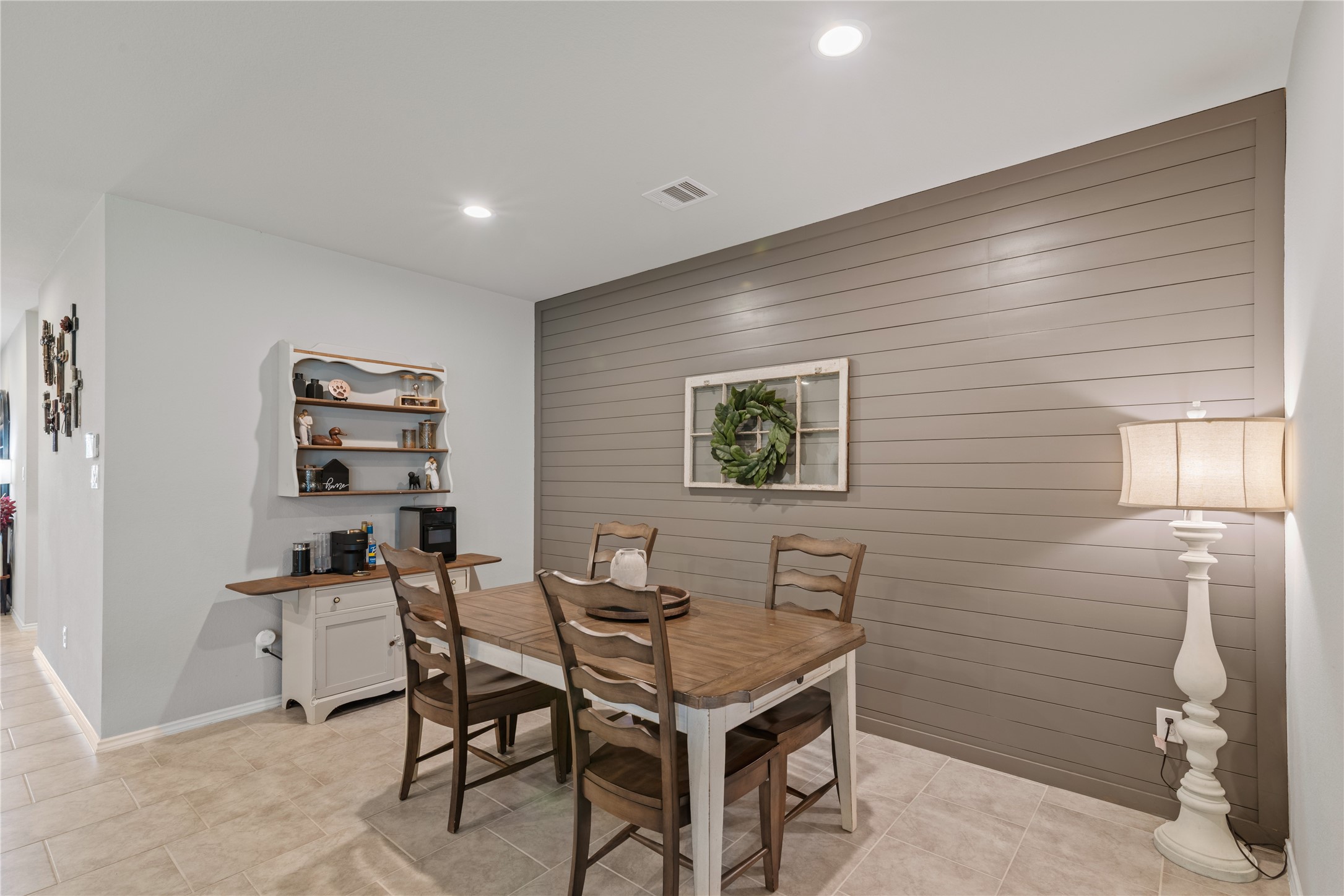 Charming dining area with a rustic shiplap accent wall, complemented by a cozy wooden table set and warm ambient lighting.