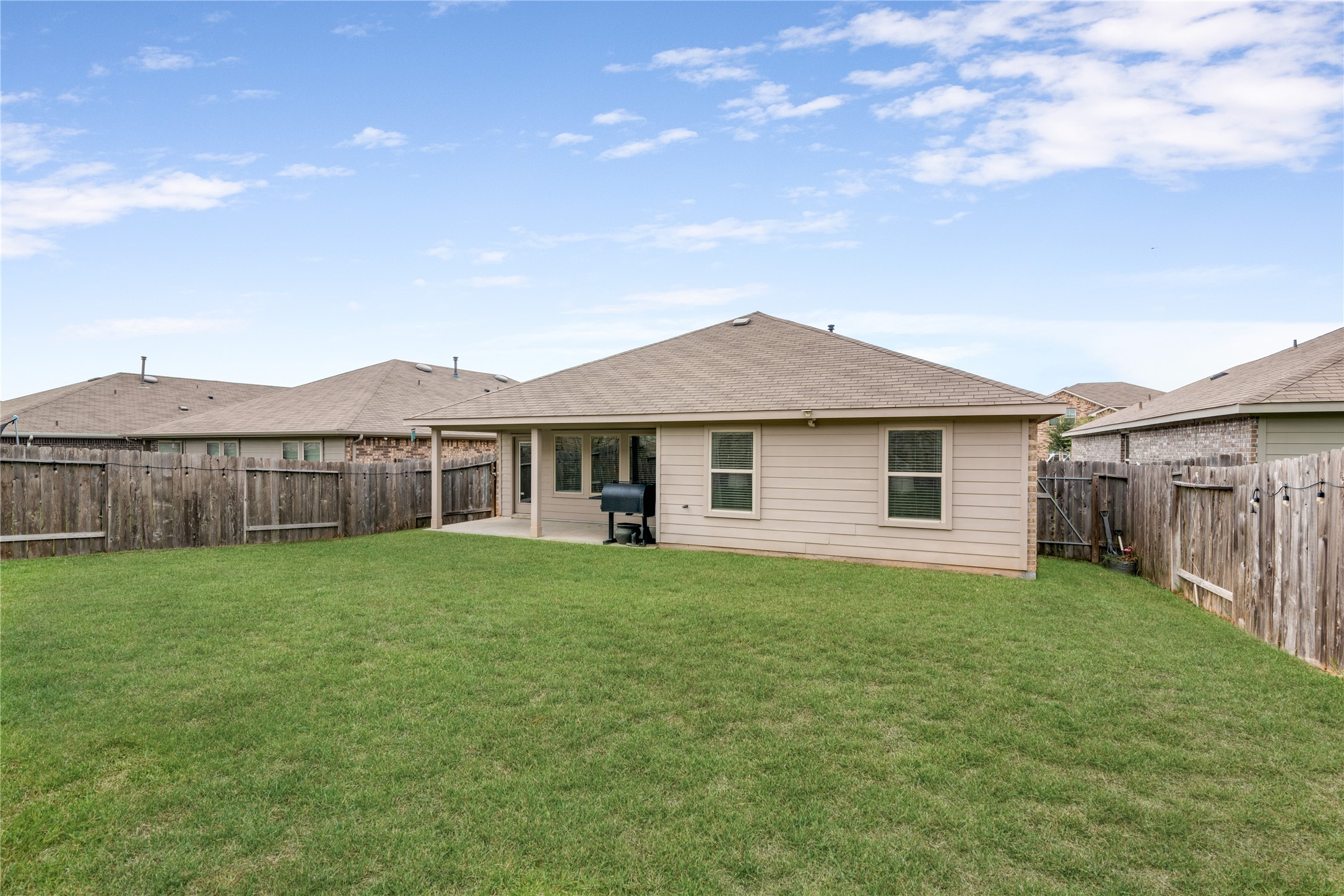 Expansive backyard with a covered patio, perfect for outdoor entertaining and relaxation.