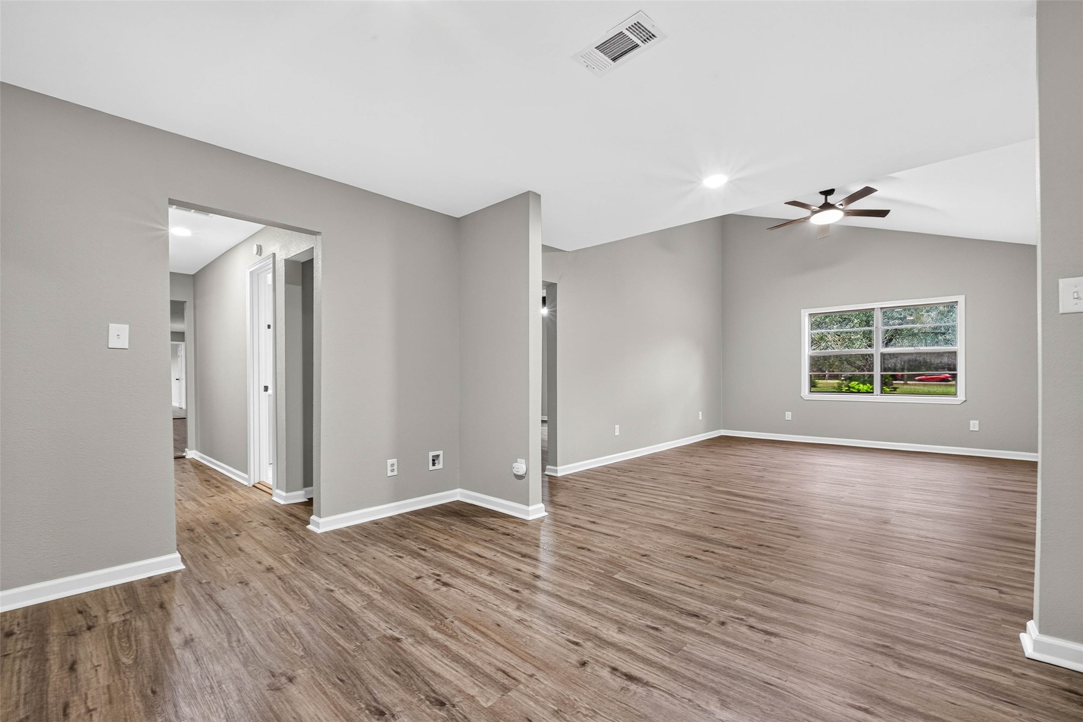 View from the kitchen showing living room and hallway leading to the back of the home