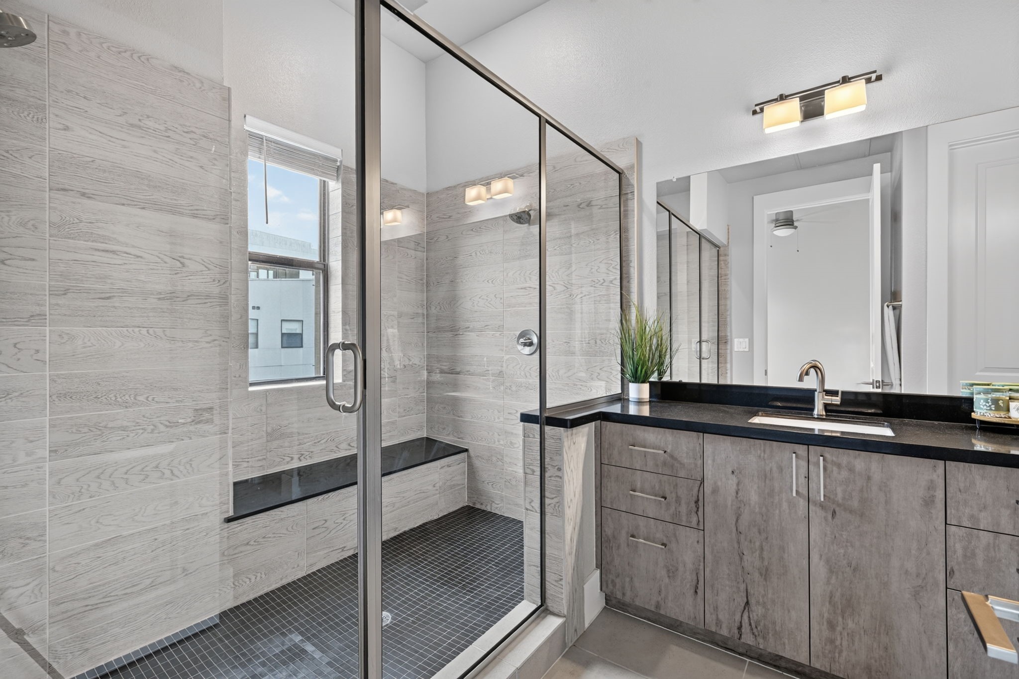 The primary bath features an oversized shower w/ bench, dual sinks, designer cabinets, commode and huge walk-in closet