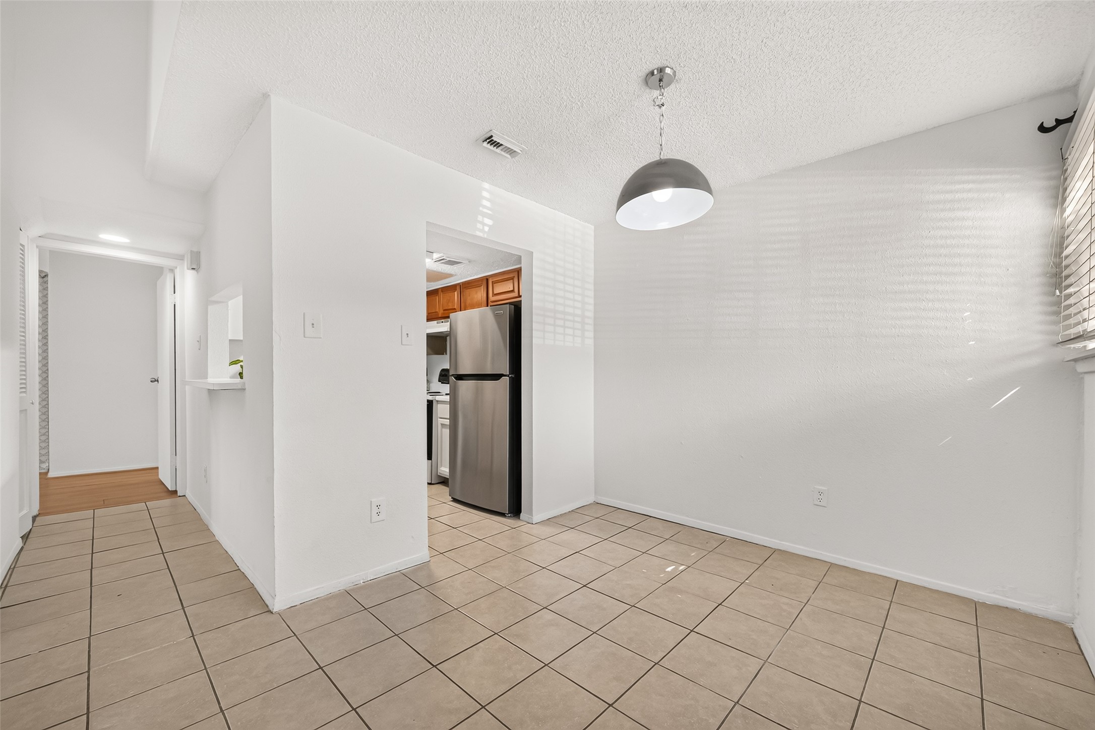 Another view from dining to kitchen and hall to the primary bedroom.