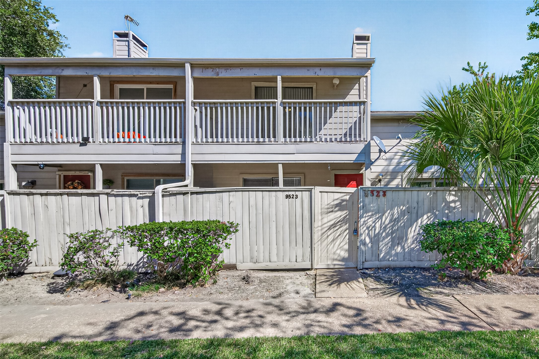 Gated entry with a wooden fence that  offers privacy for yur front porch.