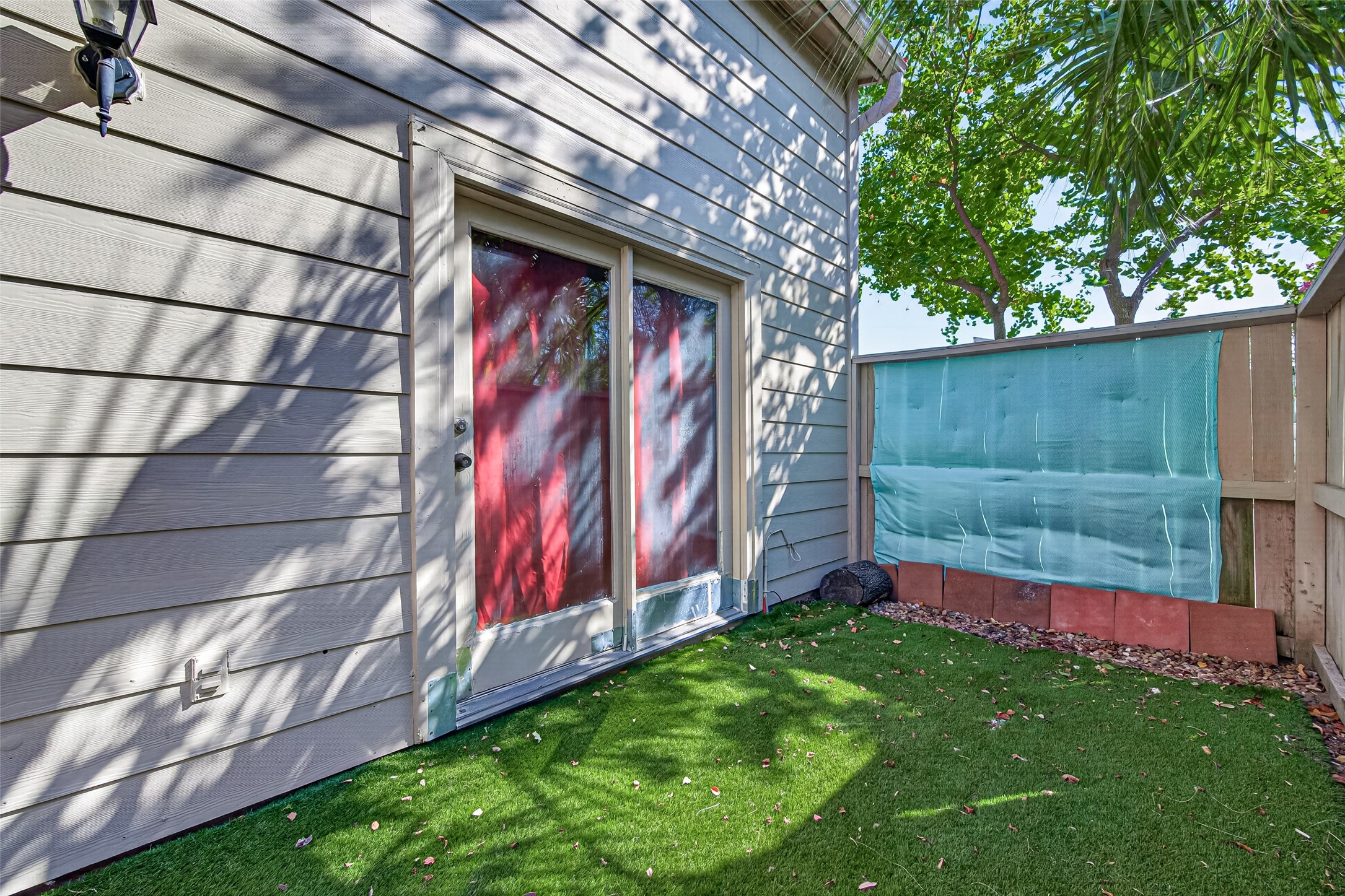 Enjoy a fully fenced front porch artificial turf for added convenience, easy maintenance, & a clean, inviting outdoor space.