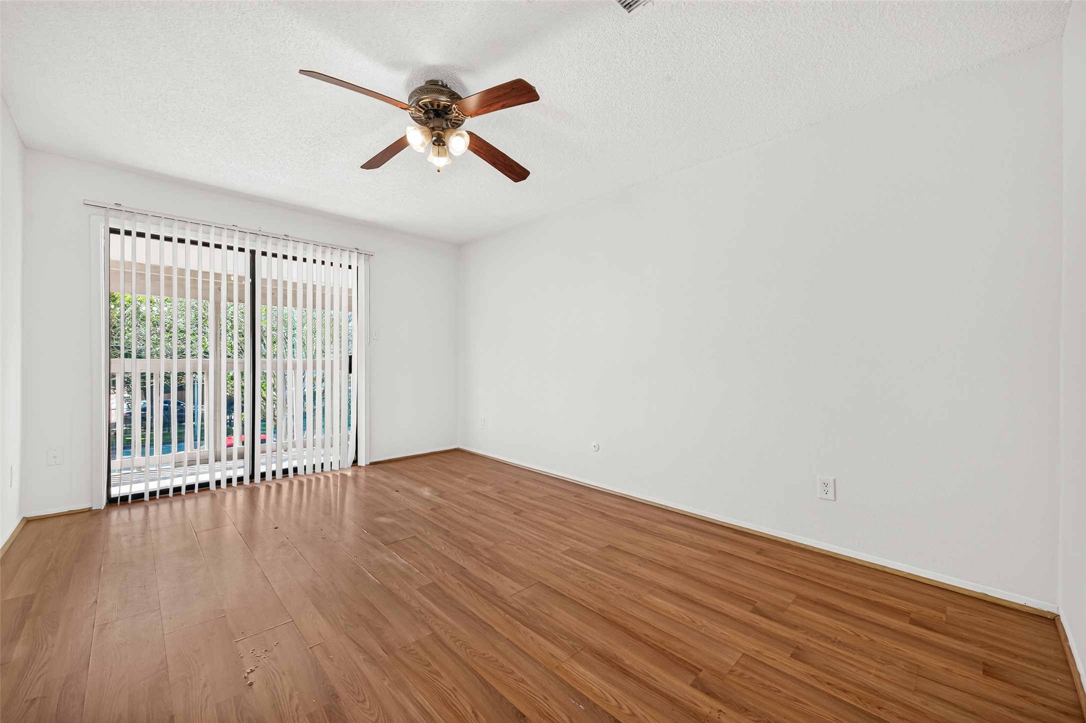 Secondary primary bedroom Bedroom with abundant natural light & sliding glass door leading to a balcony.