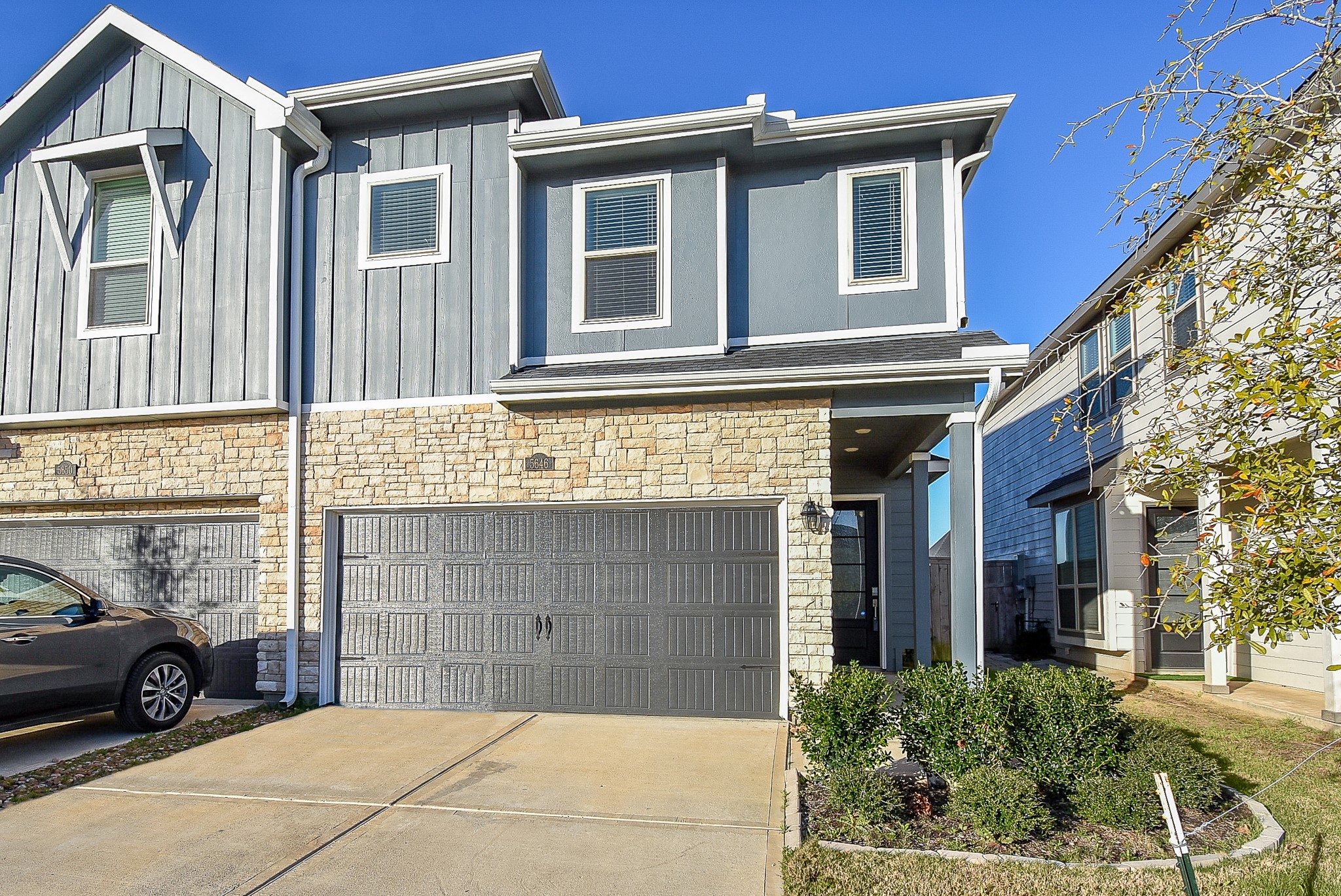 Welcome to this modern two-story townhome featuring a stone and blue board-and-batten exterior in beautiful Cross Creek Ranch