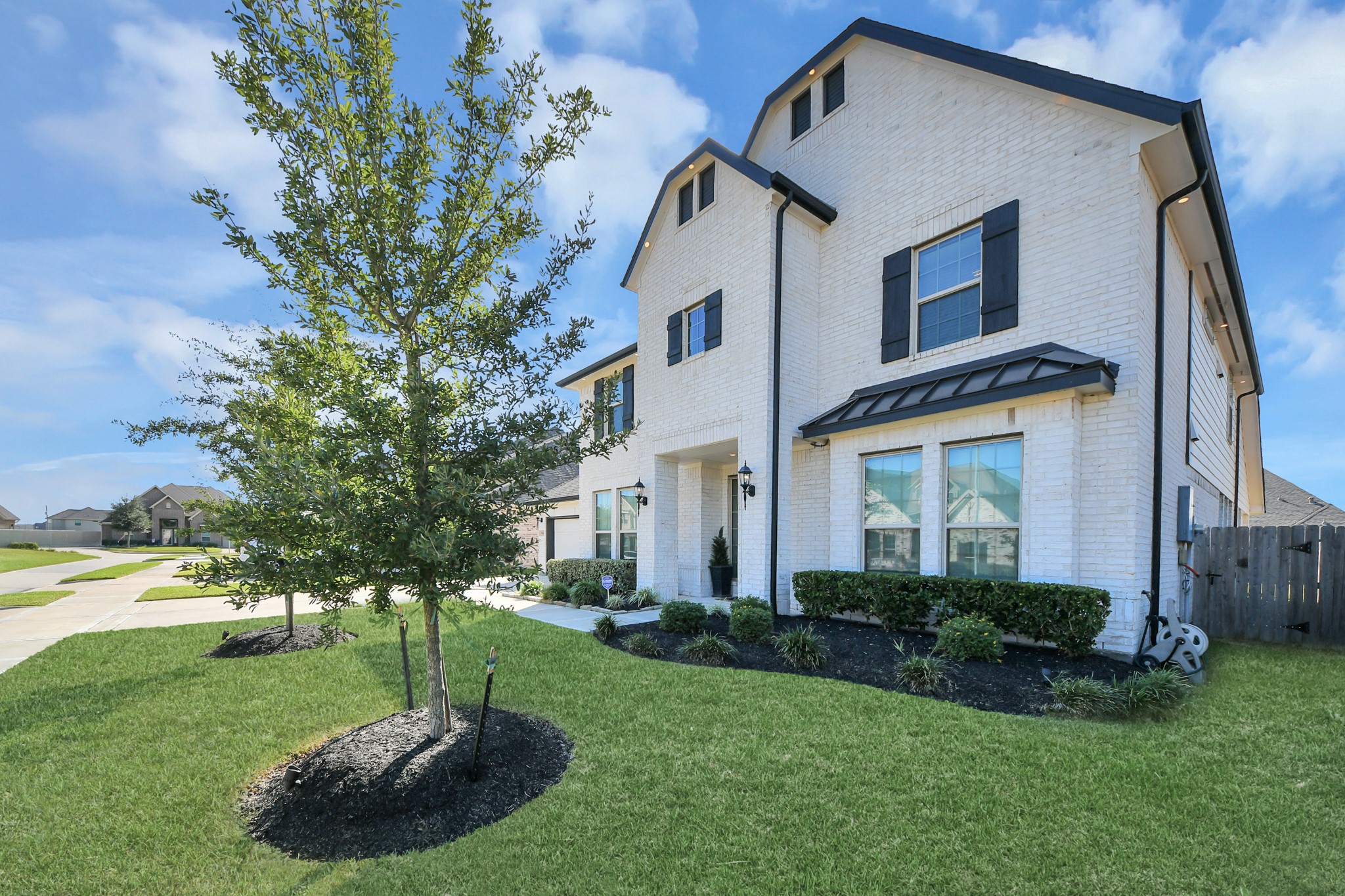 Elegant two-story home with a charming brick exterior, well-maintained landscaping, and inviting curb appeal in a quiet neighborhood.