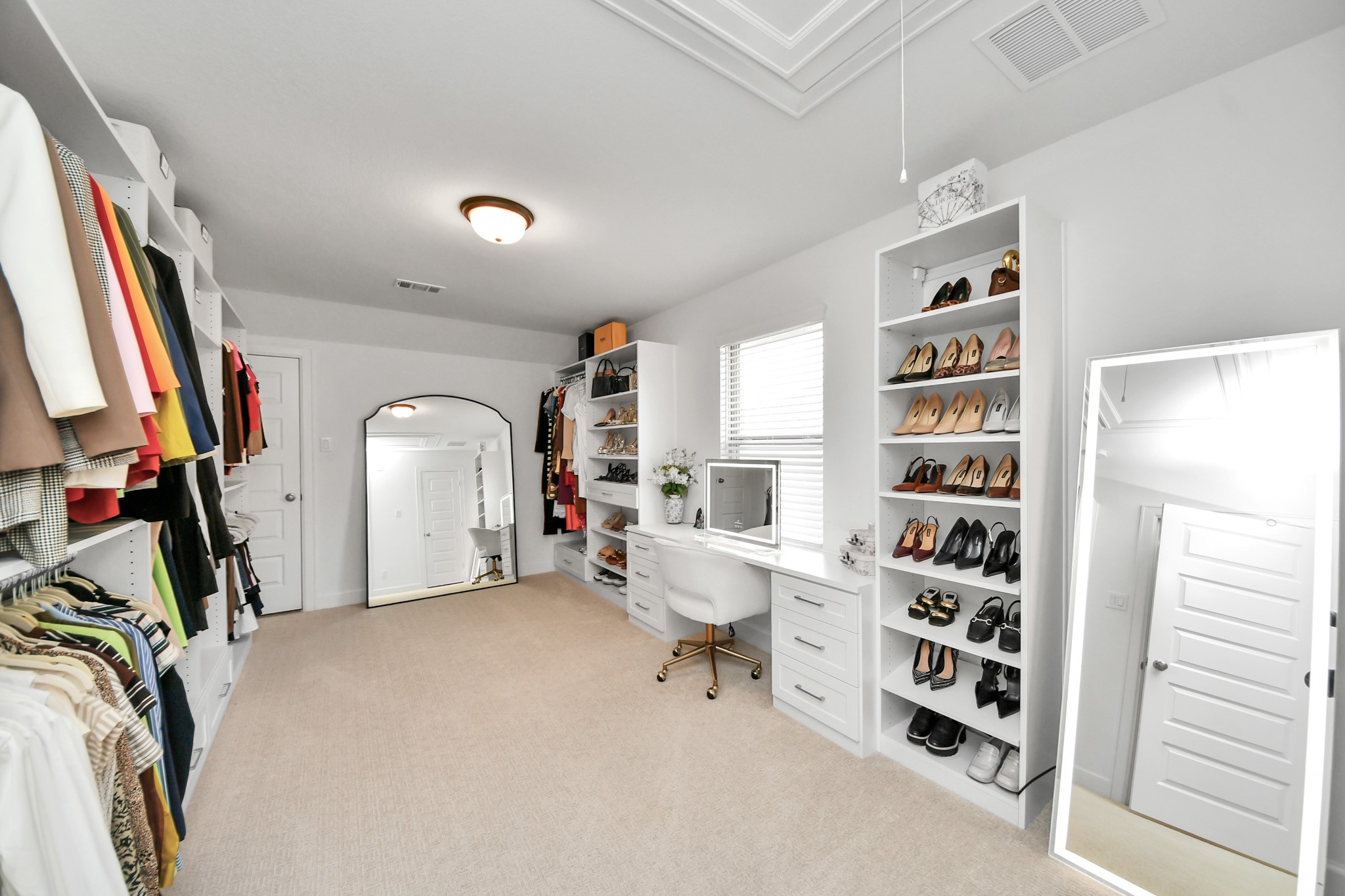 Bedroom converted into a Custom California Closet with built-in shelving, ample hanging space, and a chic vanity area for all your storage and dressing needs.