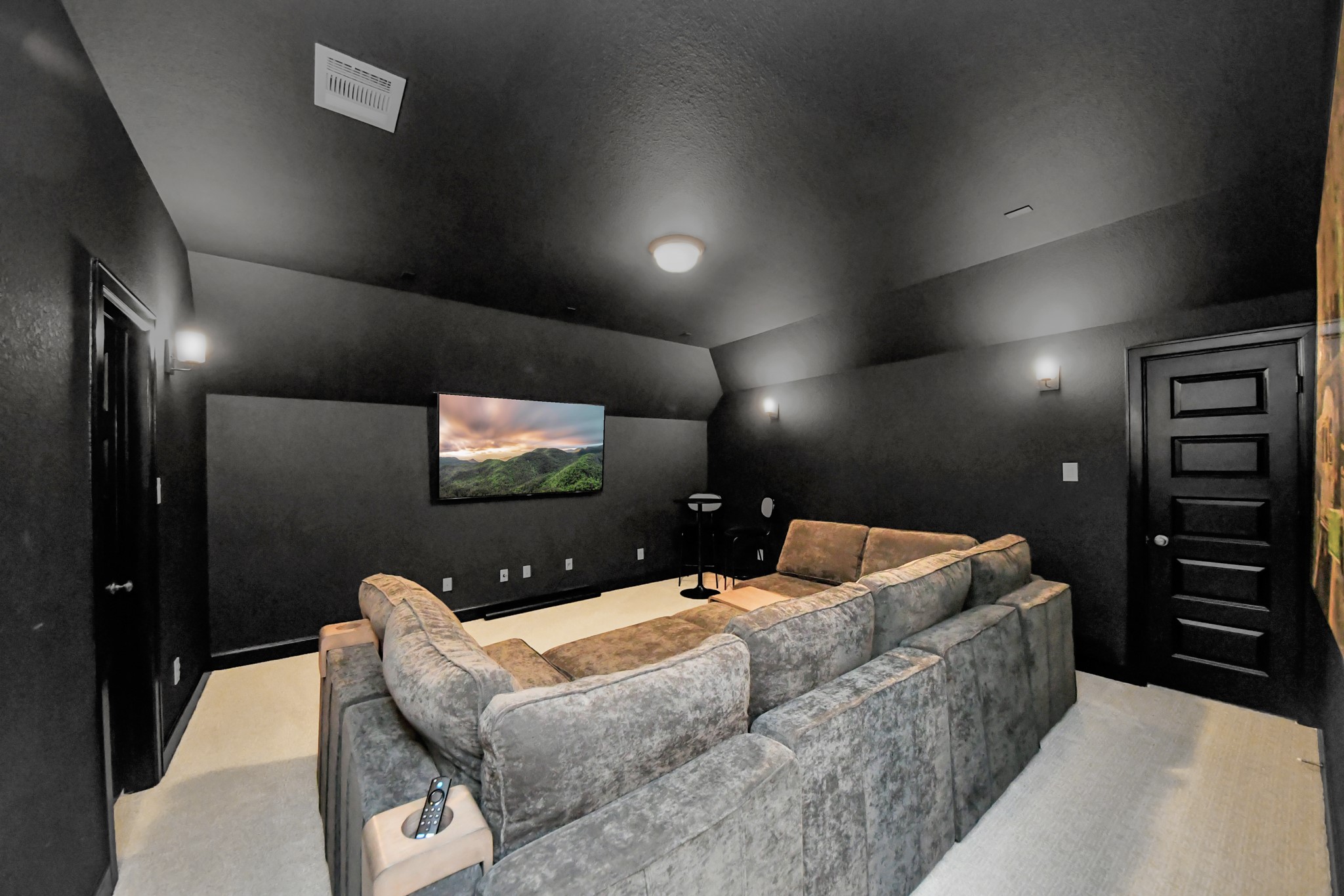 Experience luxury entertainment in this sleek home theater, featuring plush sectional seating, ambient lighting, and a large wall-mounted screen for an immersive viewing experience.