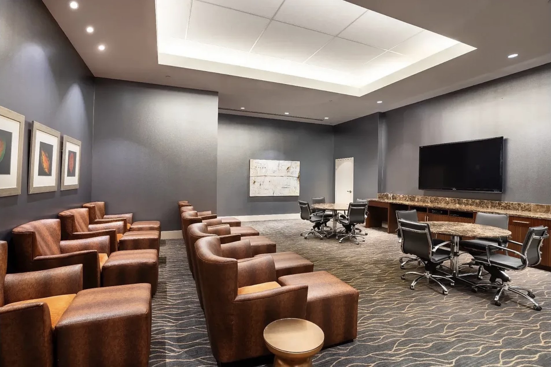 Unwind or connect in the resident media lounge, featuring oversized leather seating, a large-screen TV, collaborative work tables, and a comfortable setting perfect for movie nights, sporting events, casual gatherings or remote work.