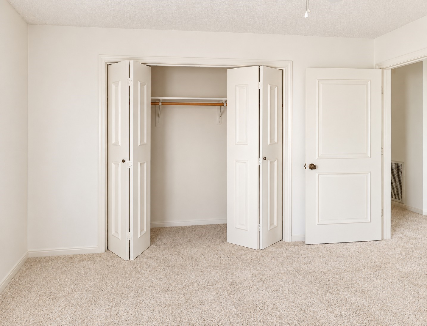 Secondary bedroom with neutral carpet and closet space.