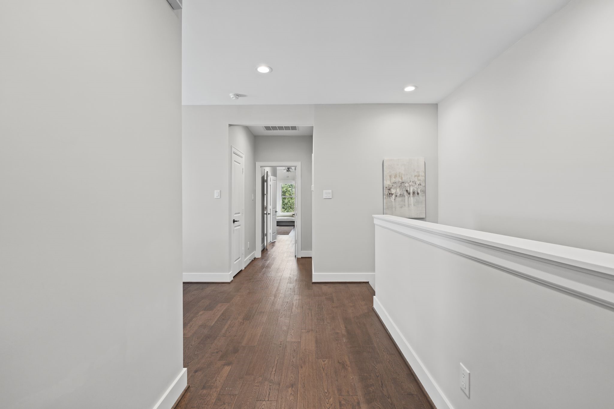 Clean lines, classic wall detailing, and continuous wood flooring create a polished transition between the home's private living quarters.