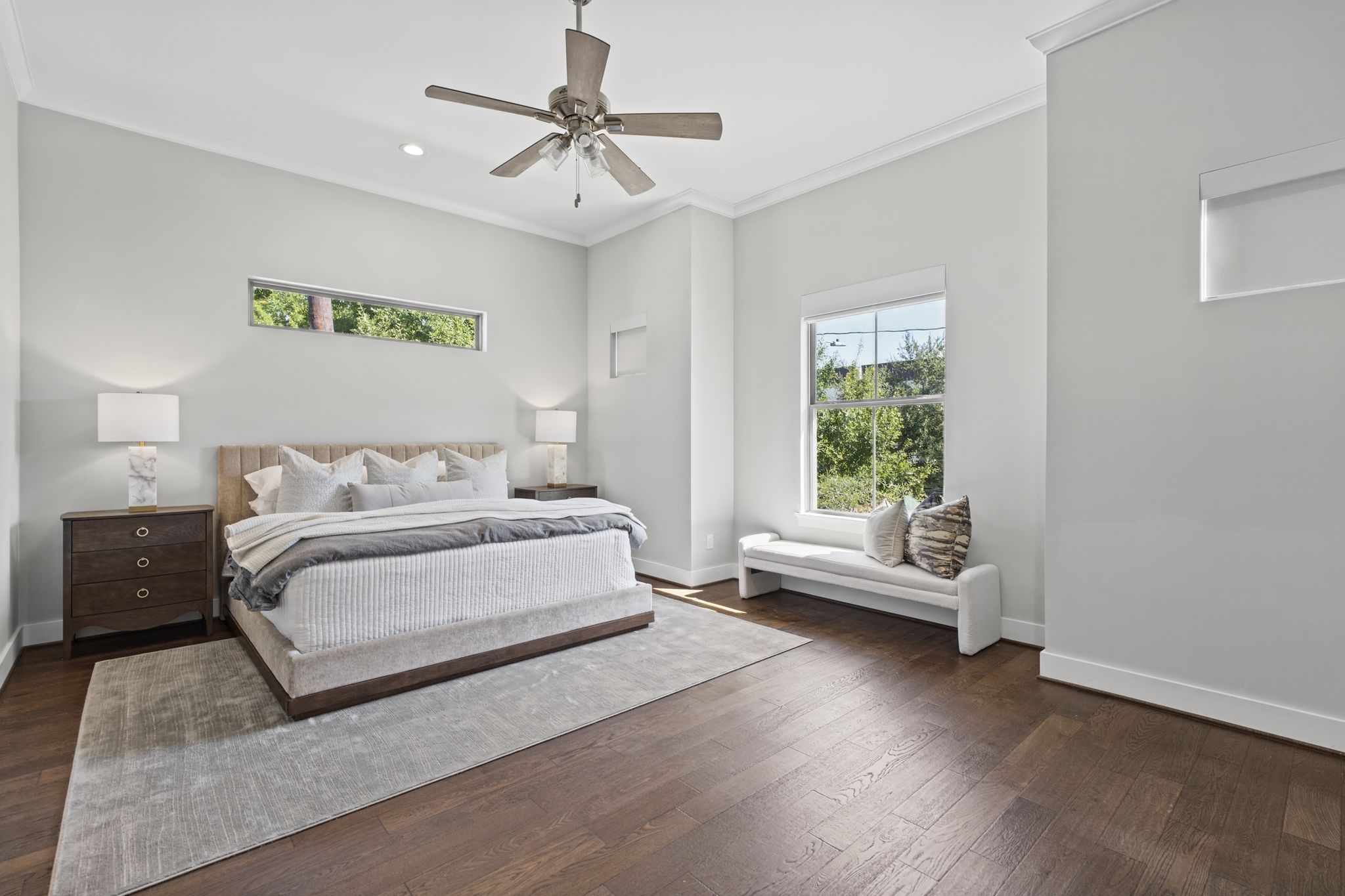 A spacious primary retreat combines soothing neutral tones, warm wood flooring, and generous windows to create a serene escape at day's end.