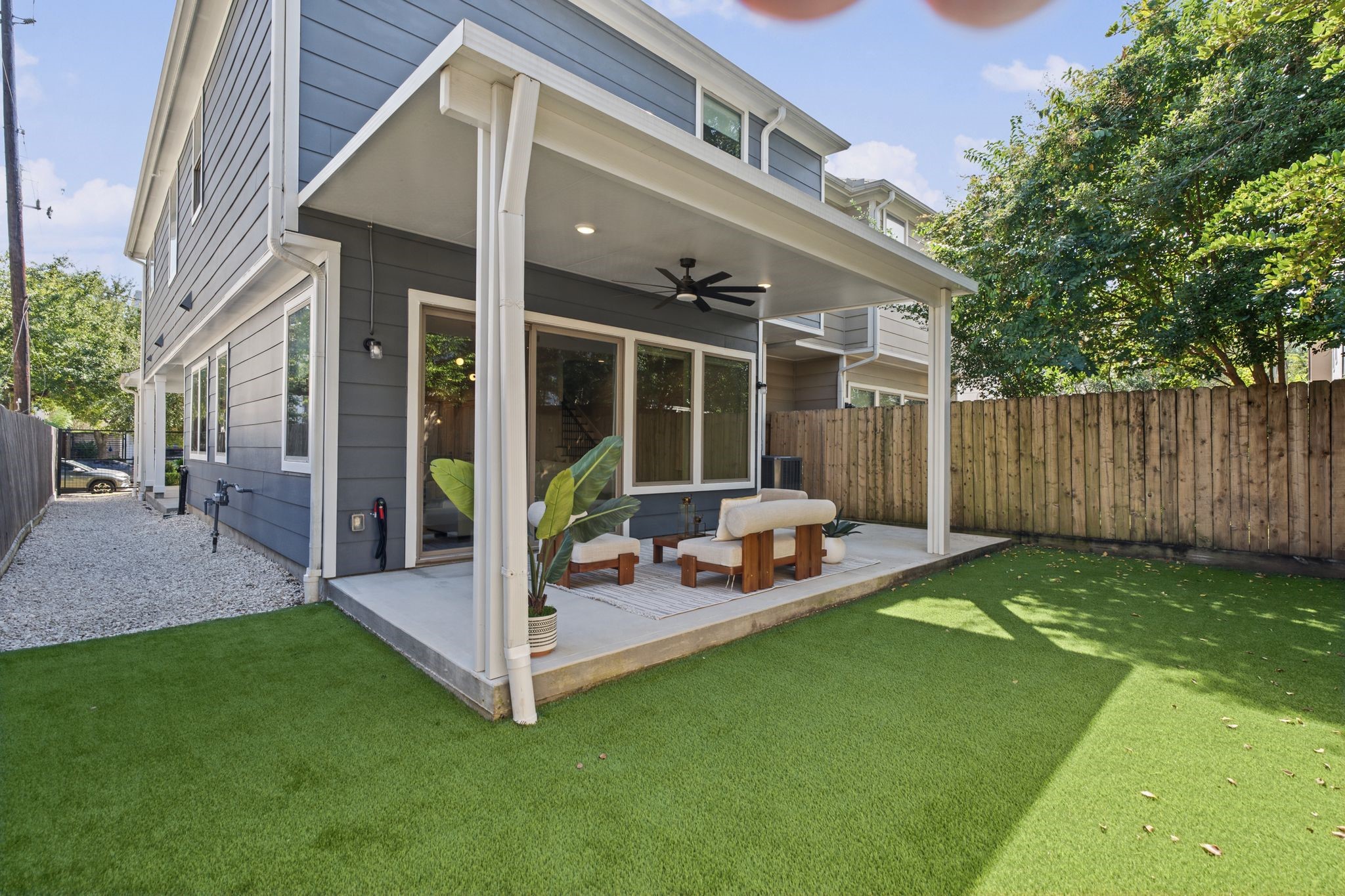 An inviting covered patio extends the living space outdoors, with a ceiling fan and room to create a comfortable lounge or al fresco dining area. Brand new turf installed!