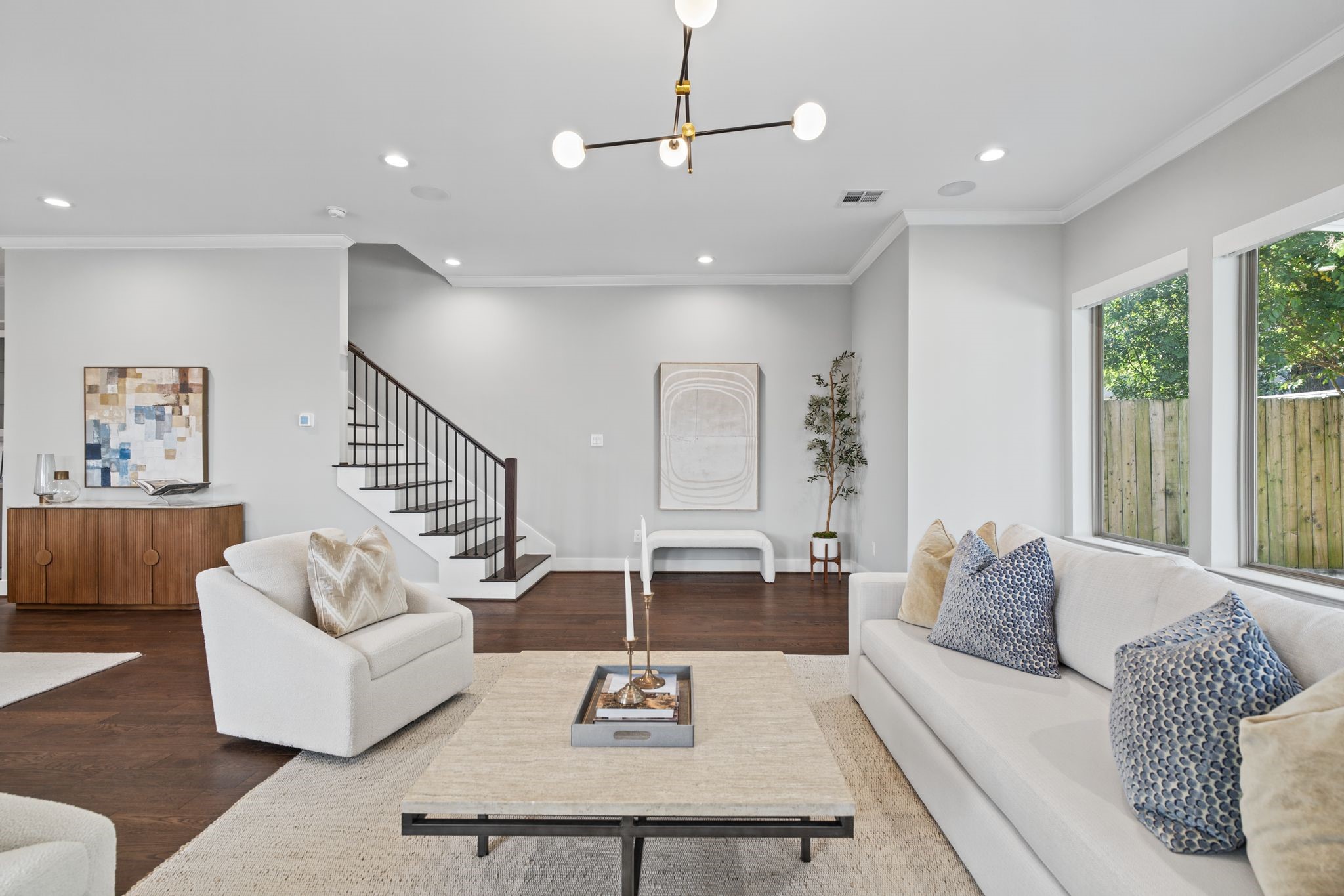 Oversized windows invite abundant natural light into this welcoming living space, where understated finishes and elegant lighting create a relaxed yet refined ambiance.