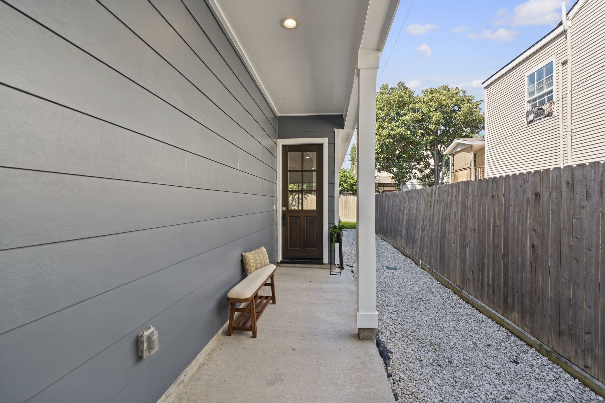 A covered entry framed by clean architectural lines and a contemporary glass-paneled door sets the tone for the refined interiors beyond.