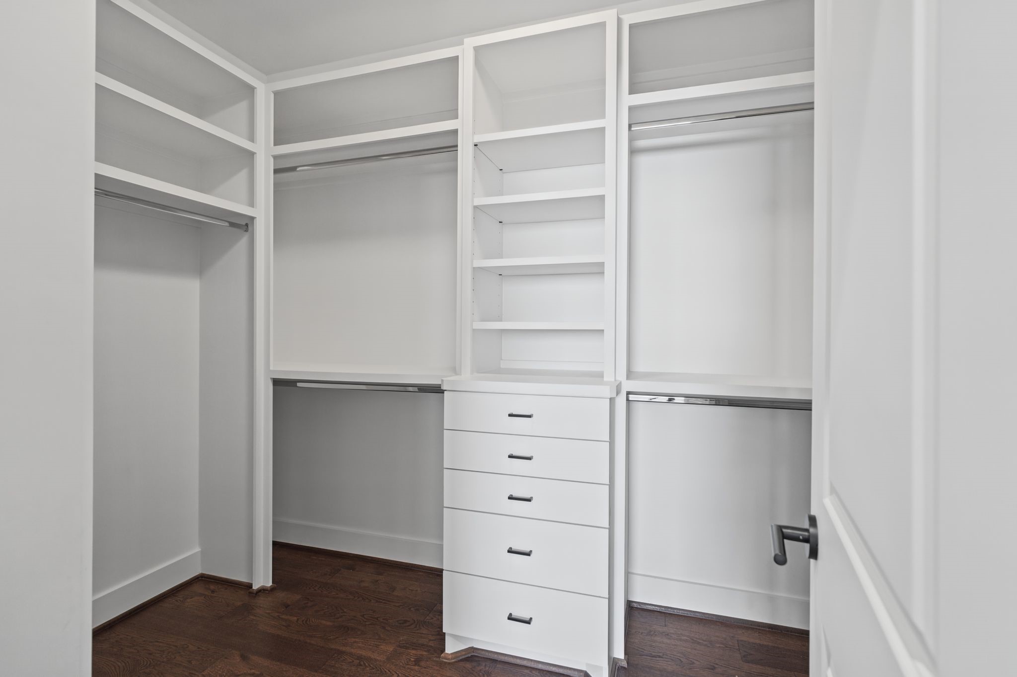 Custom-style built-in organization with generous hanging space, shelving, and drawers offers an elegant, practical solution for wardrobe storage.