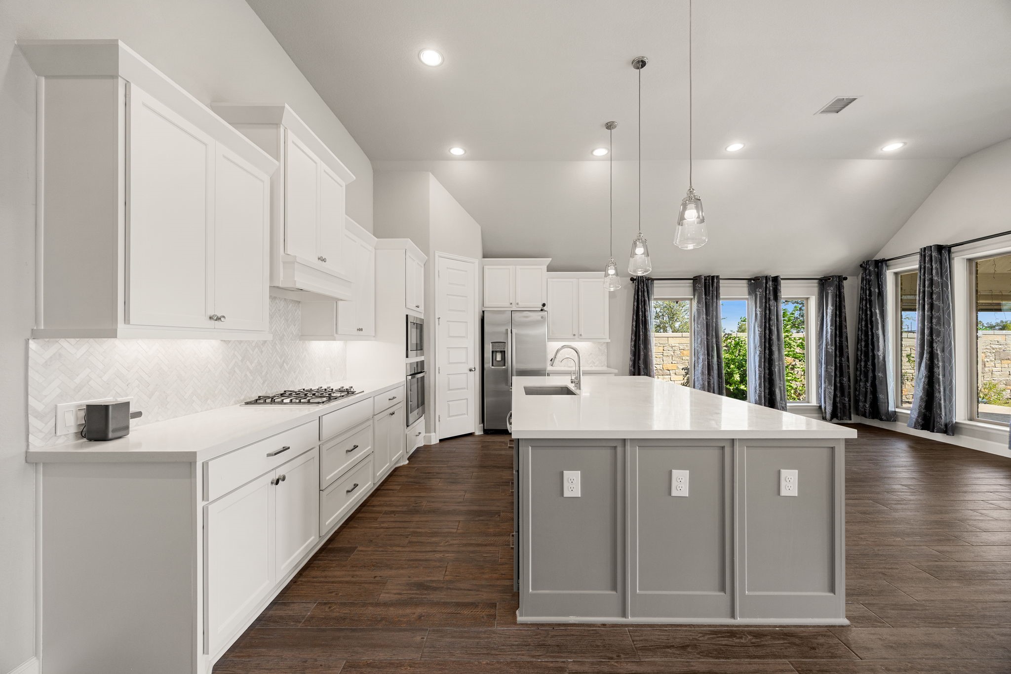 Sunlight takes center stage in this stunning open layout. The wall of windows offers a bright, refreshing backdrop whether you are brewing morning coffee or gathering around the island for a casual evening.