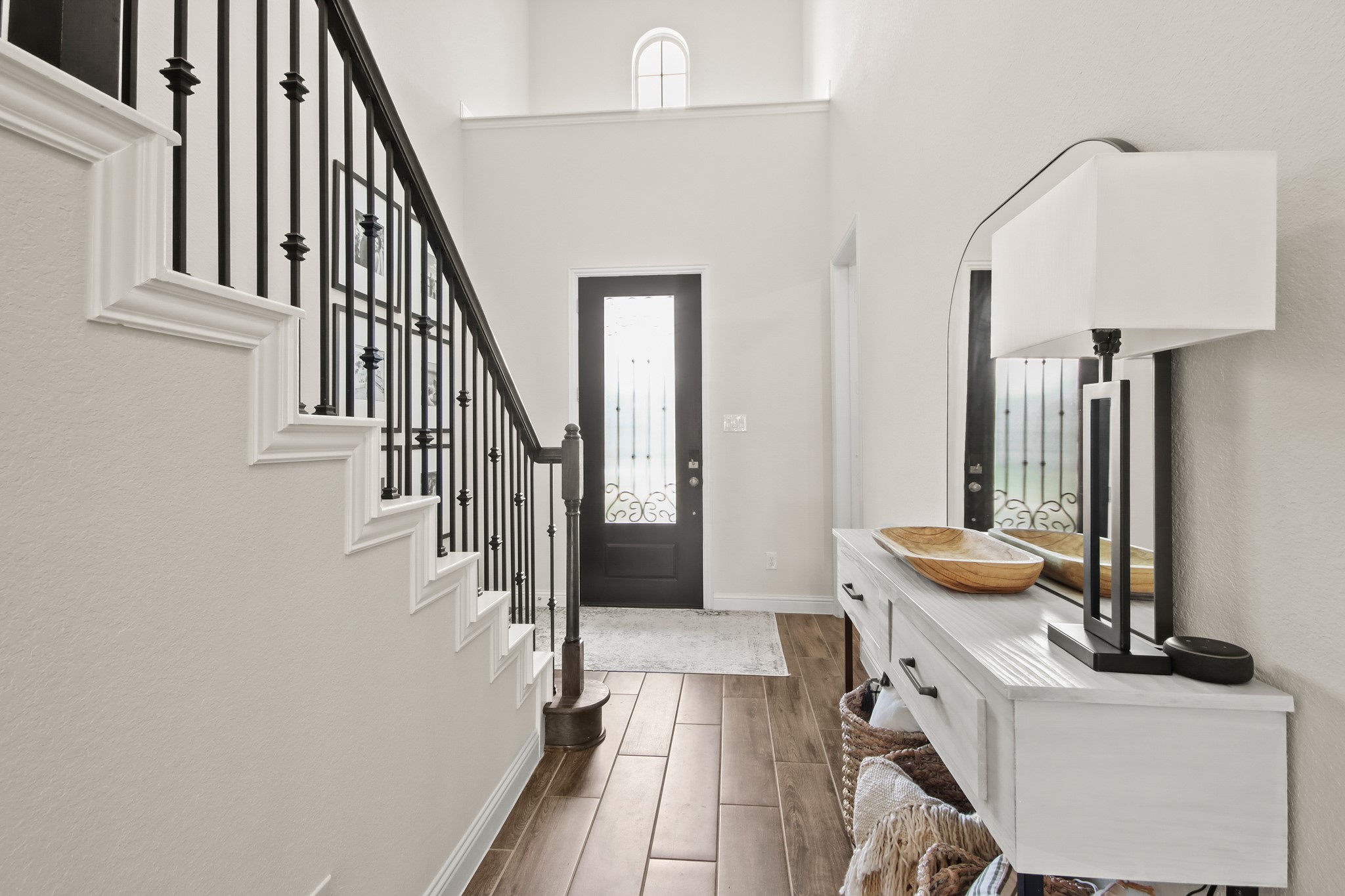 Two story entry with wood tile flooring and light colored painted walls