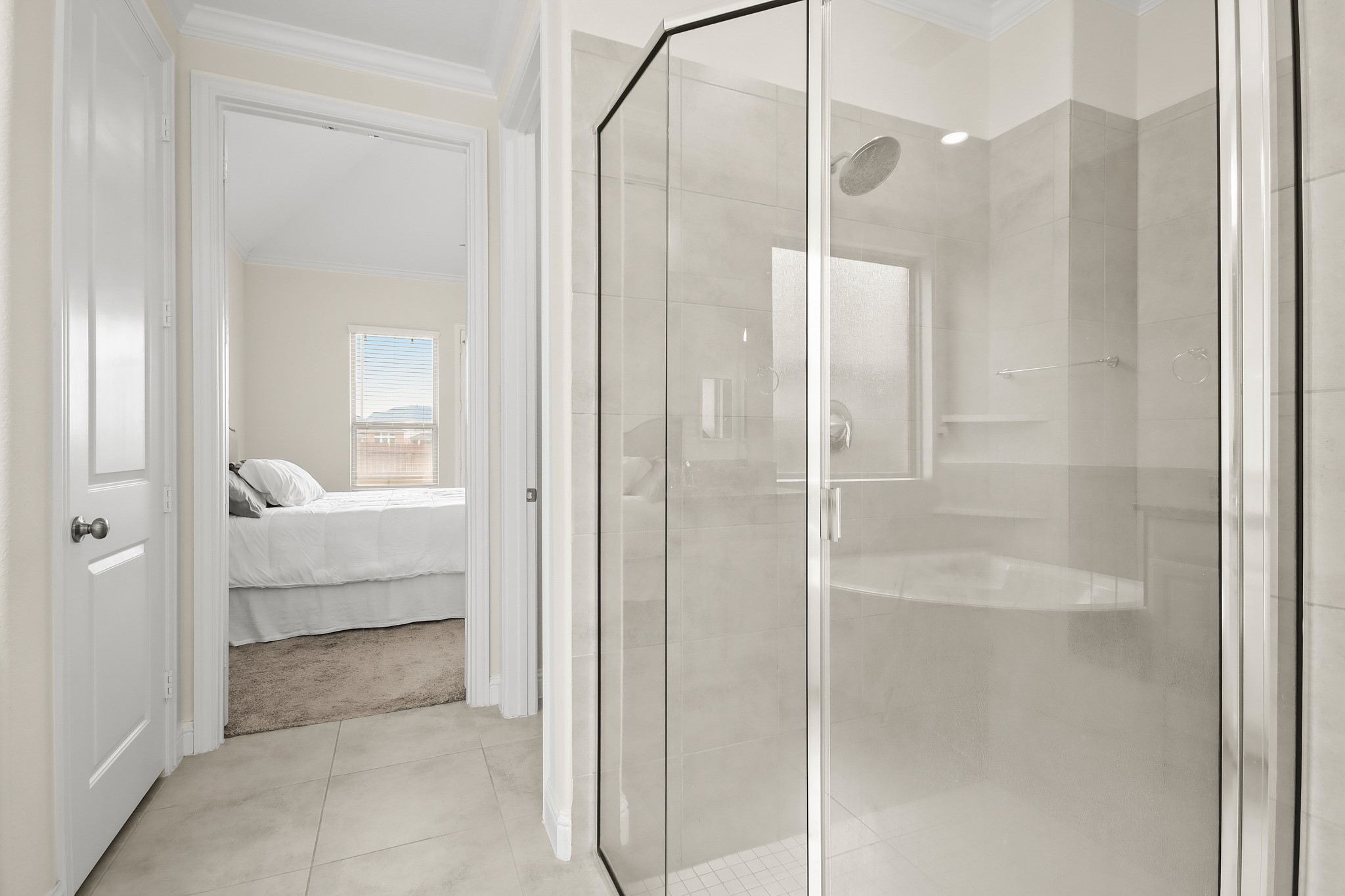 Expansive primary bathroom with upgraded back splash, corner soaking tub, his and her vanities and glass shower.