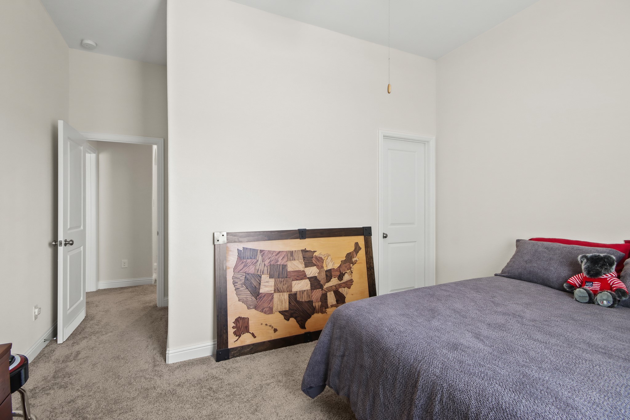Neutral carpet, ceiling fan and window for natural light.