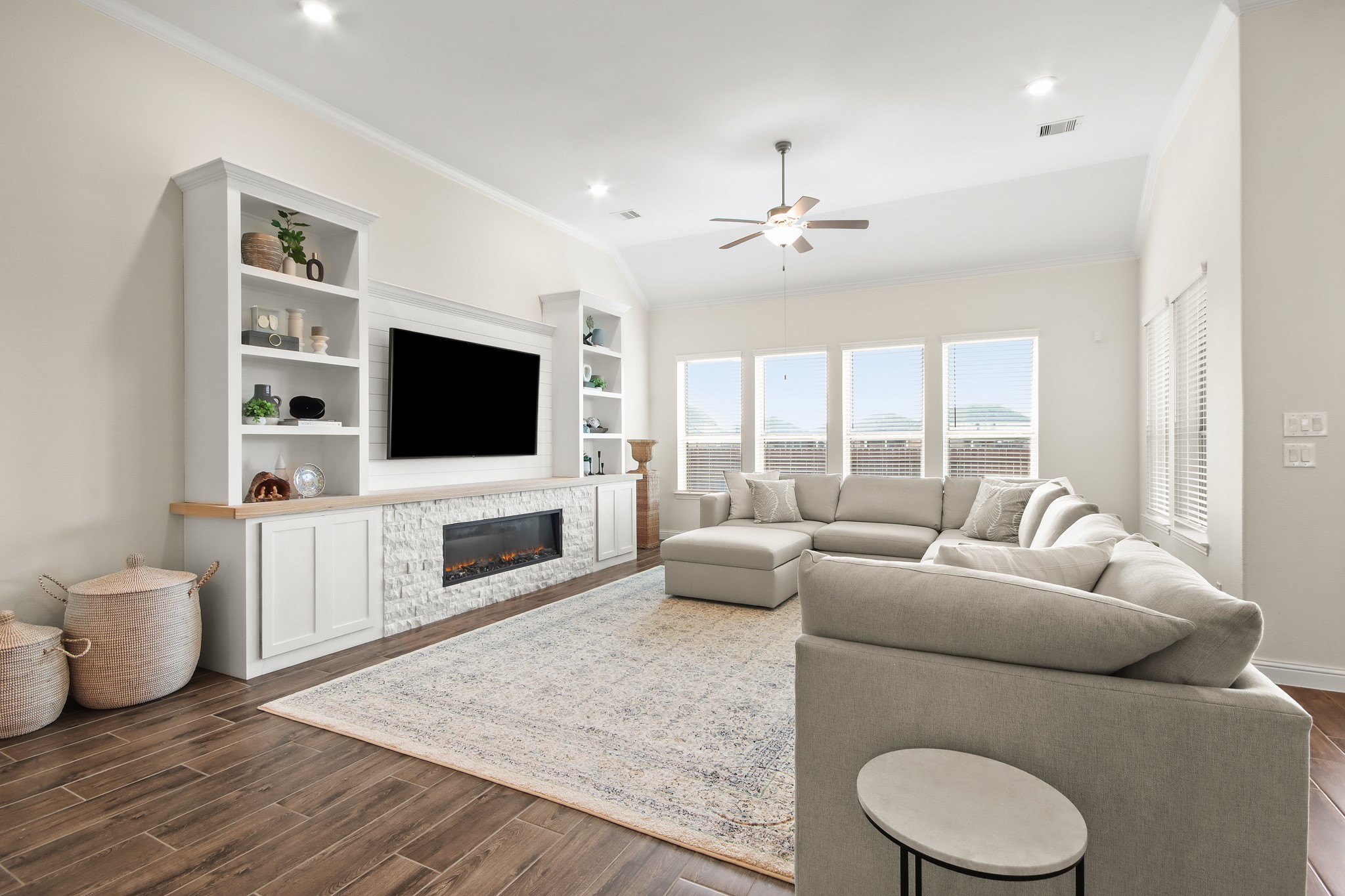 Custom built entertainment wall with cabinets, display shelving, Shiplap accent and stone gas fireplace.
