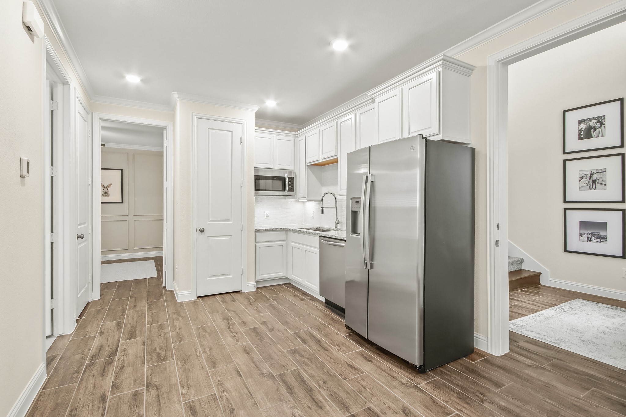The Next Gen has light colored walls, wood tile flooring, full kitchen, large bedroom and oversized bathroom.